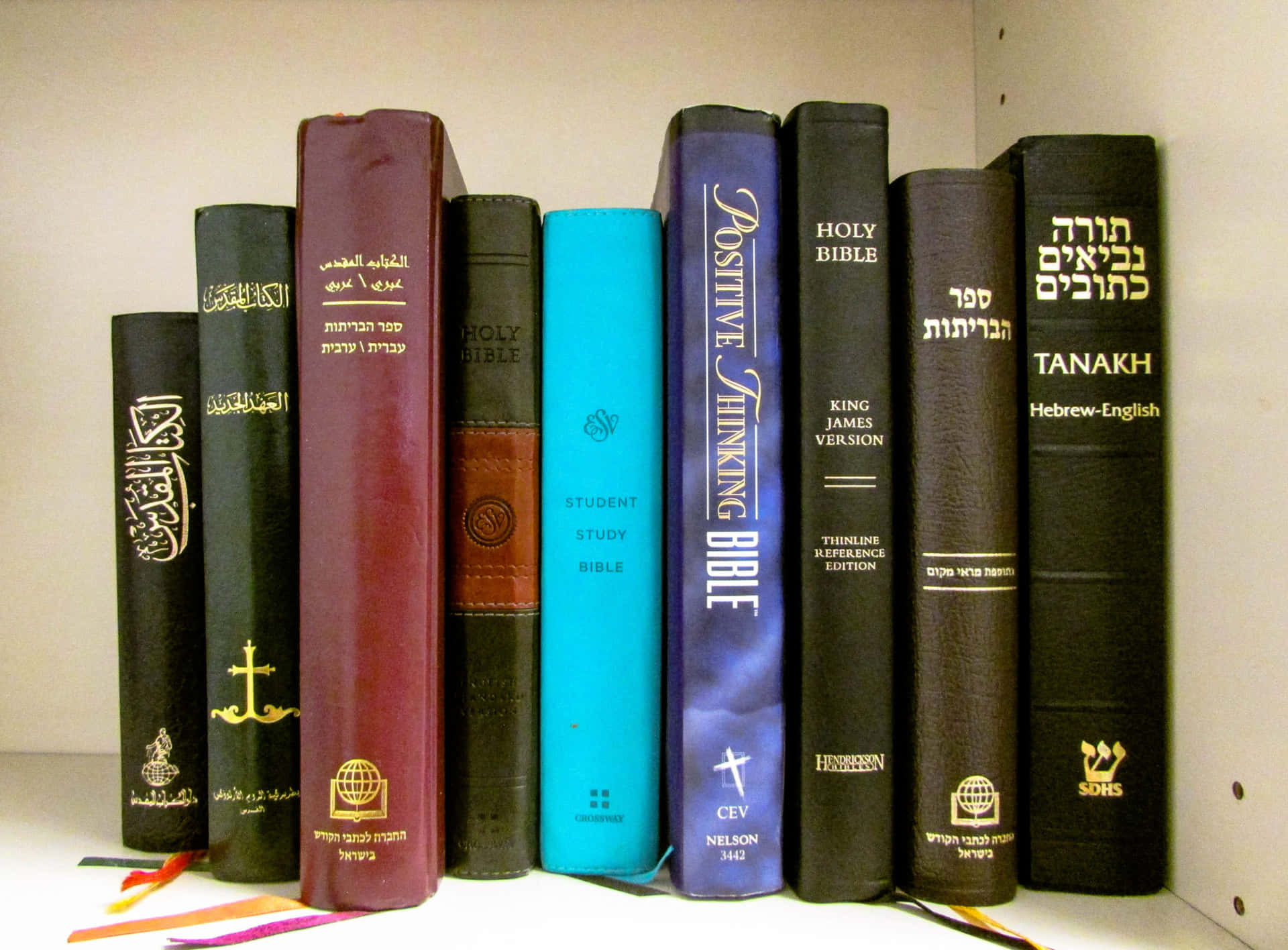 白色書架上的一排多語言宗教書籍。