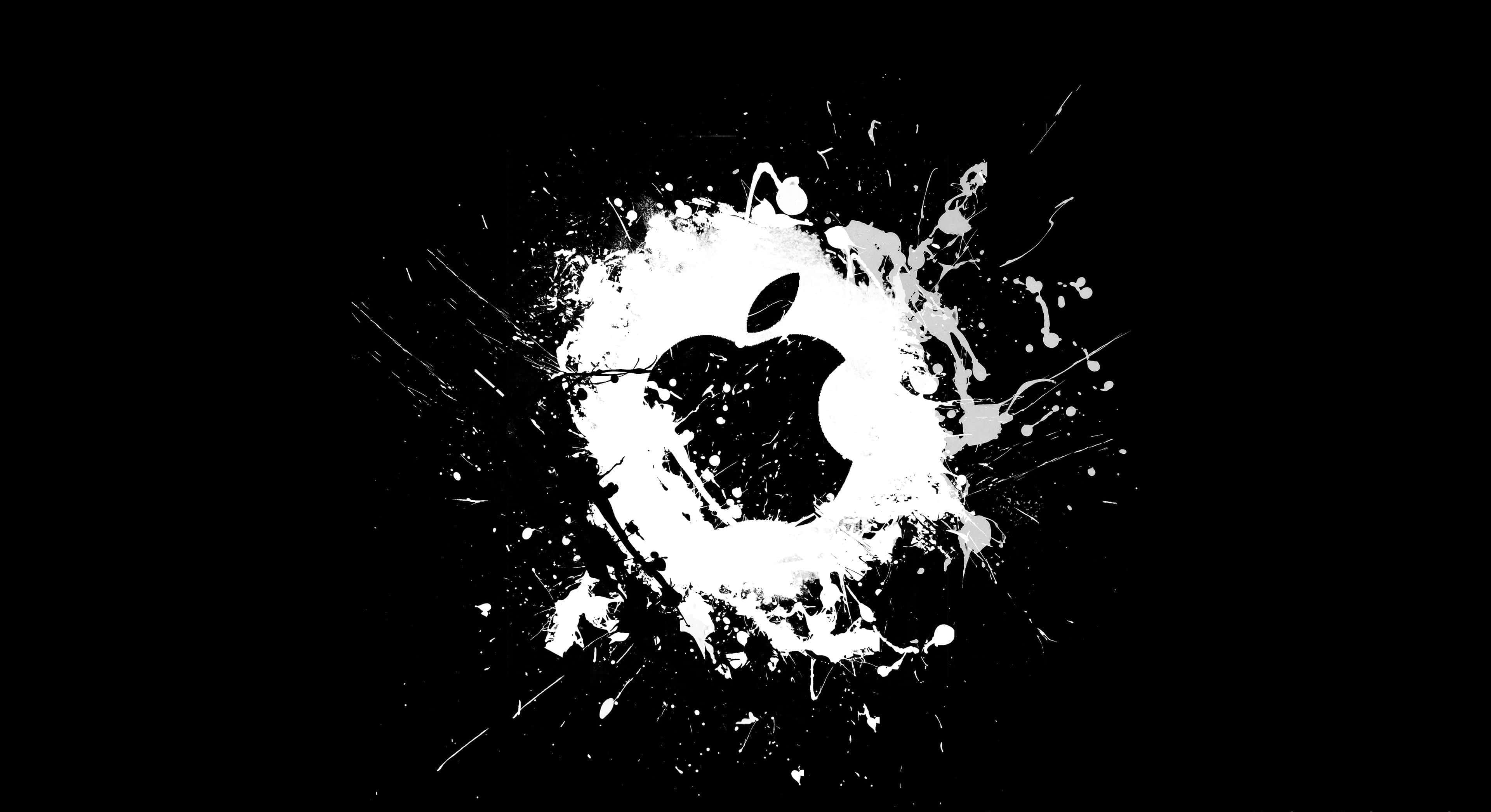 4K Apple 桌布 壁紙 — 在純黑背景上，一道銳利的白色油漆飛濺形成 Apple 標誌，帶有動態滴落和噴濺效果。
