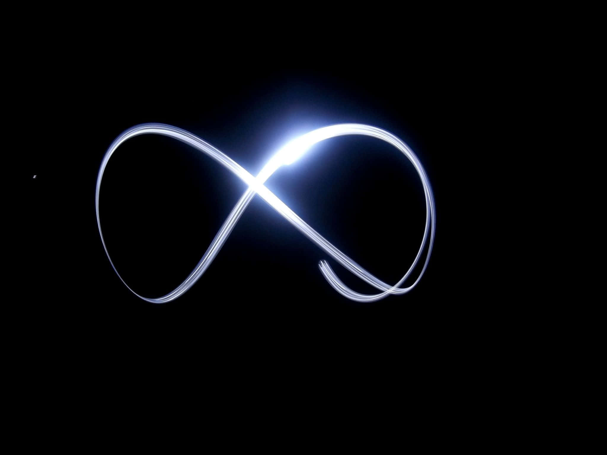 infinity 桌布 壁紙 — 在純黑色背景上以光繪創作的發光白色無限符號。