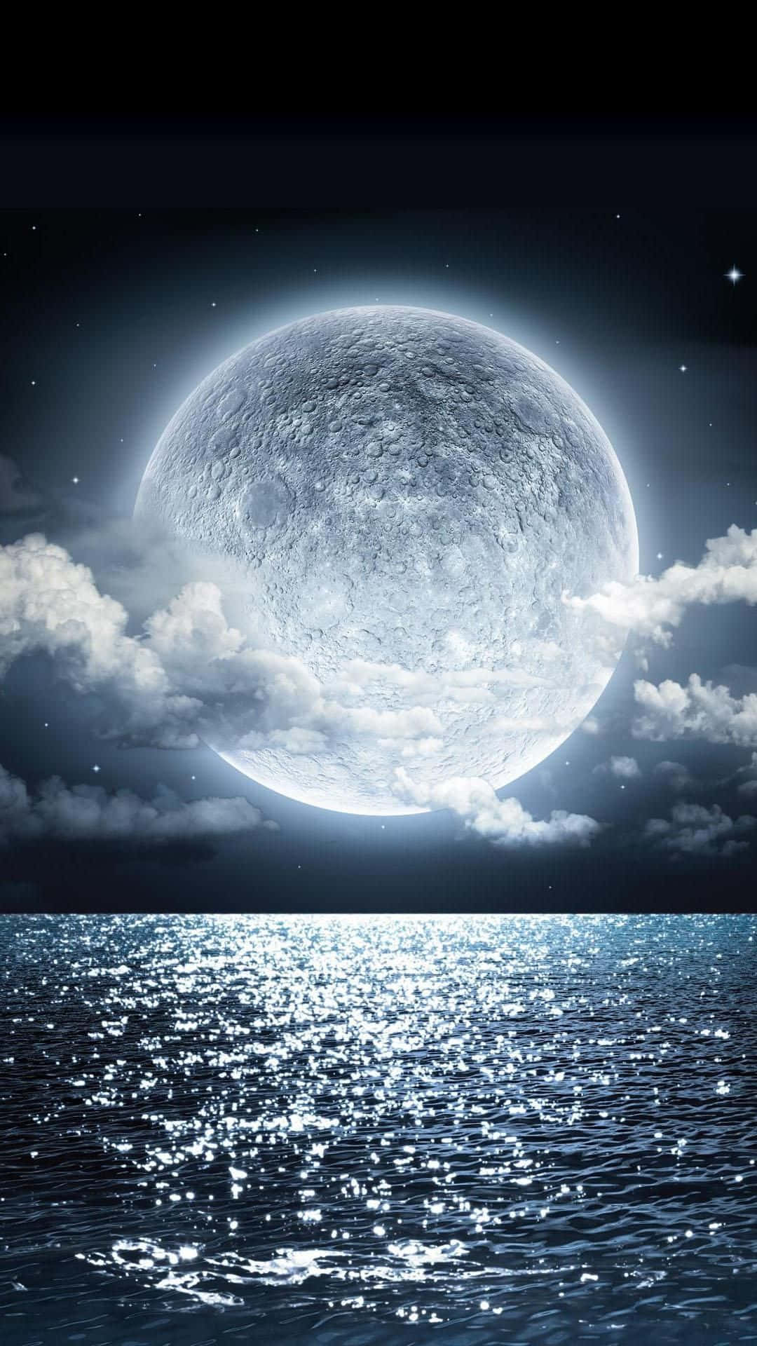 Beautiful Moon 桌布 壁紙 — 在繁星點點的夜空下，一輪巨大而細節豐富的月亮在蓬鬆的雲層後方閃耀，照耀著波光粼粼的海洋。