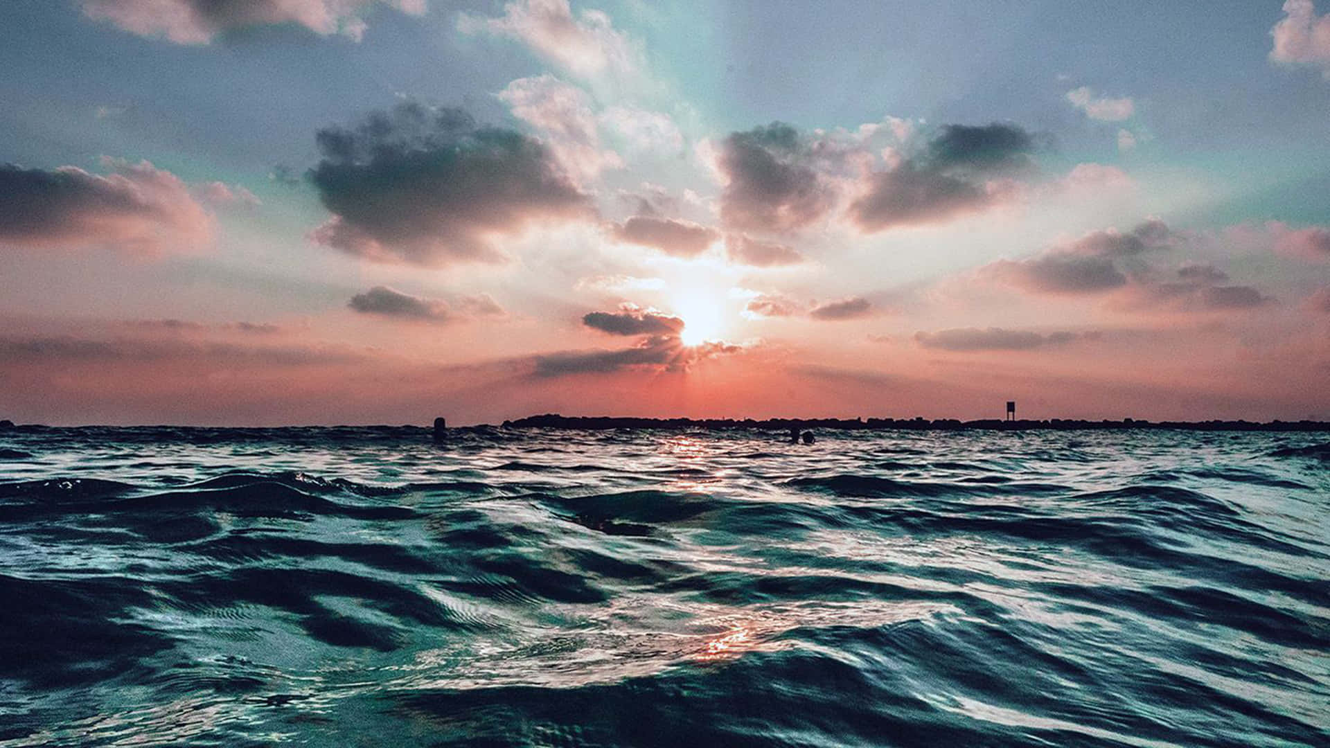 夕陽下的海洋，有雲和遠方陸地