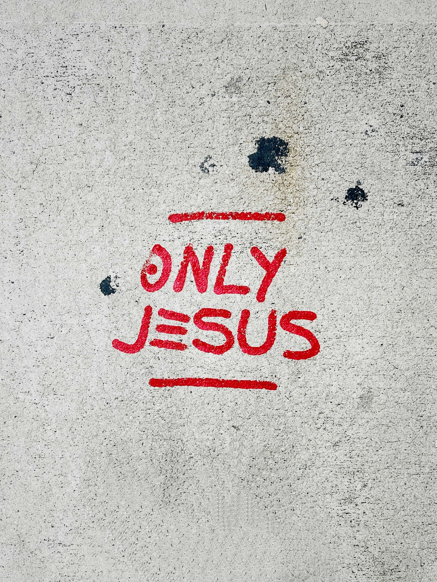 粗糙混凝土牆上的紅色噴漆文字「only jesus」