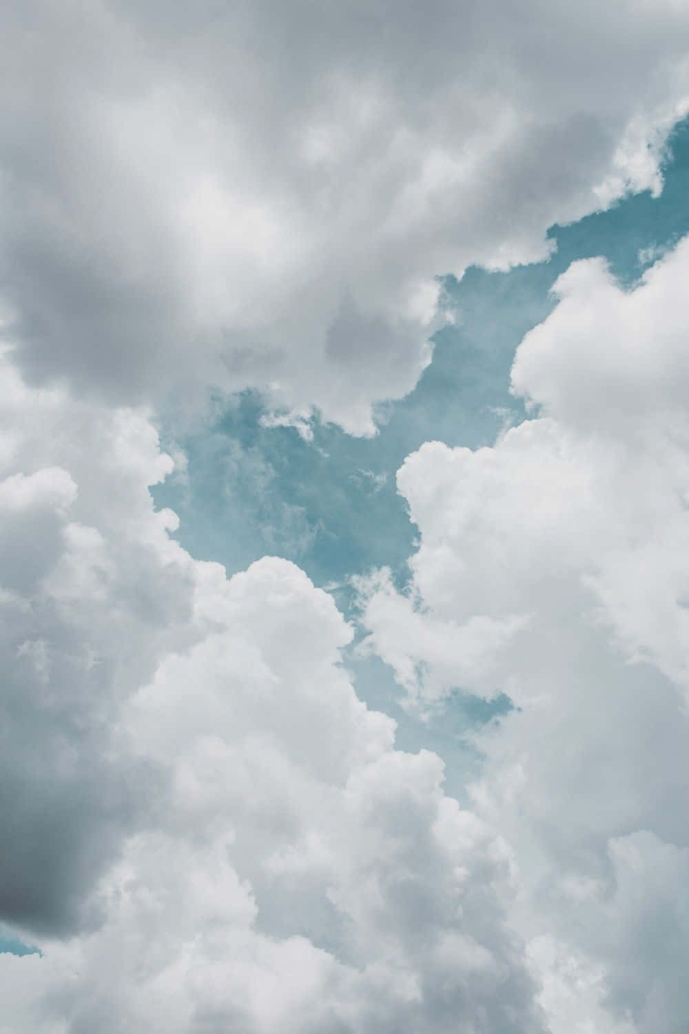 戲劇性的天空，蓬鬆的白雲映襯著柔和的青藍色背景。