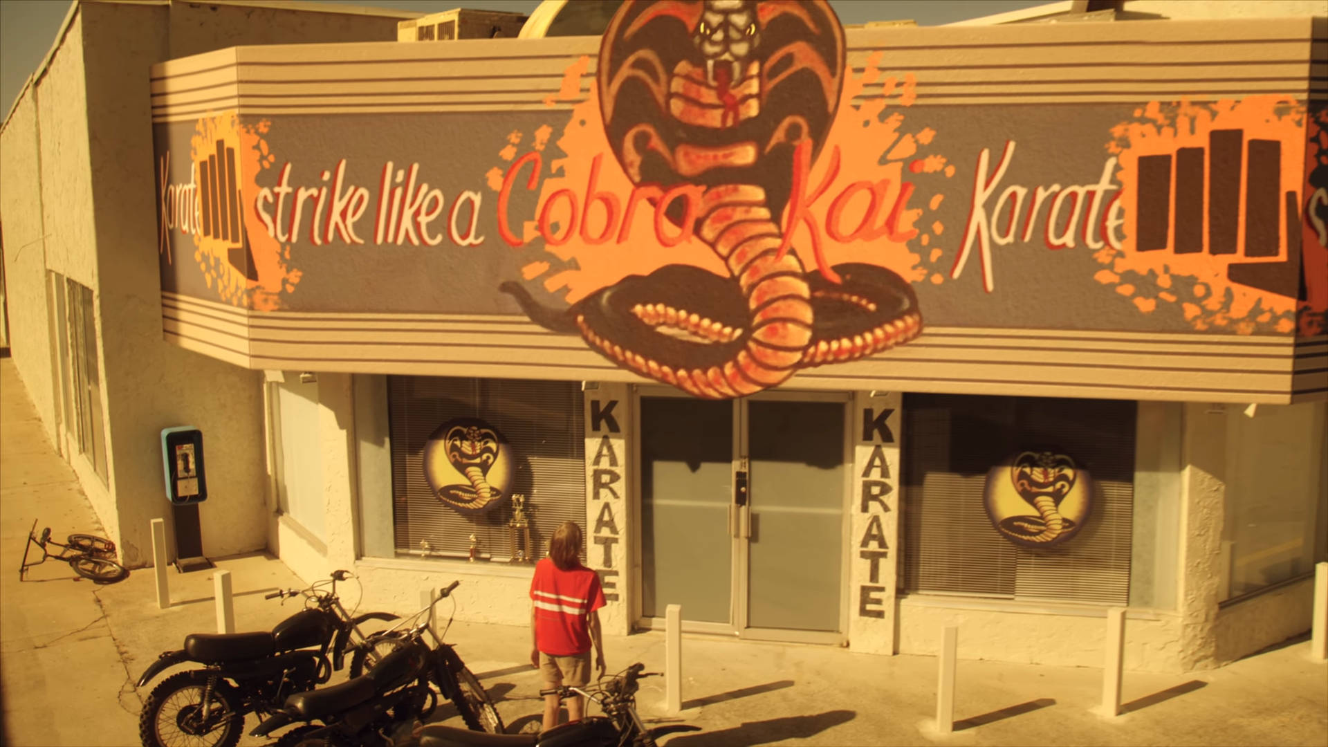 Cobra Kai 空手道道場，有眼鏡蛇壁畫和停在外面的摩托車。