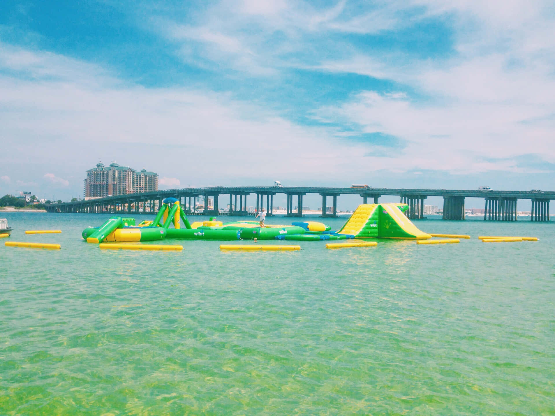 色彩繽紛的充氣水上樂園漂浮在橋附近平靜的海水上。
