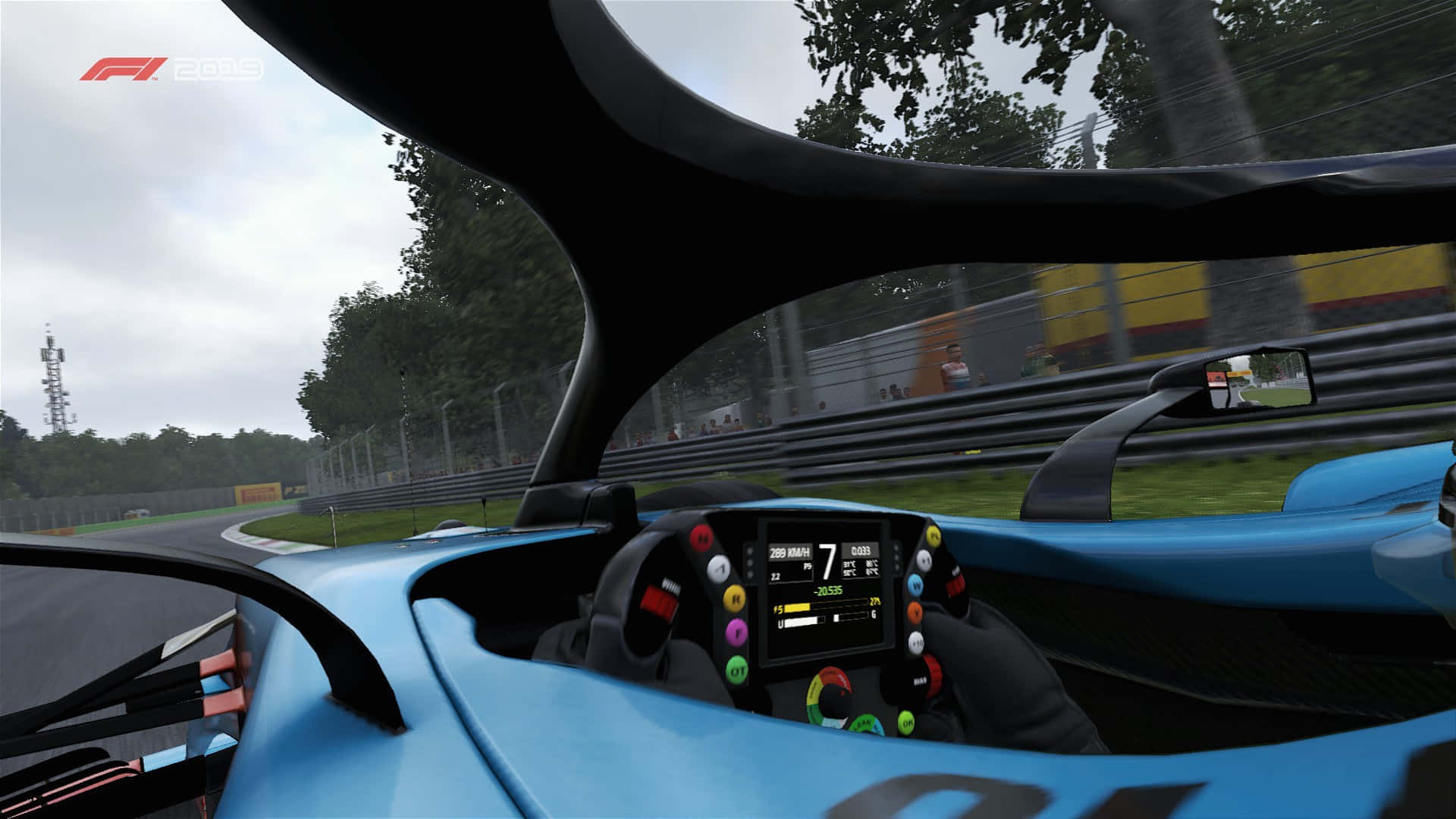 在賽道上體驗F1 2019的極致刺激 壁紙 — 從藍色賽車內部以第一人稱視角高速穿越潮濕森林賽道，模糊的綠植和護欄。