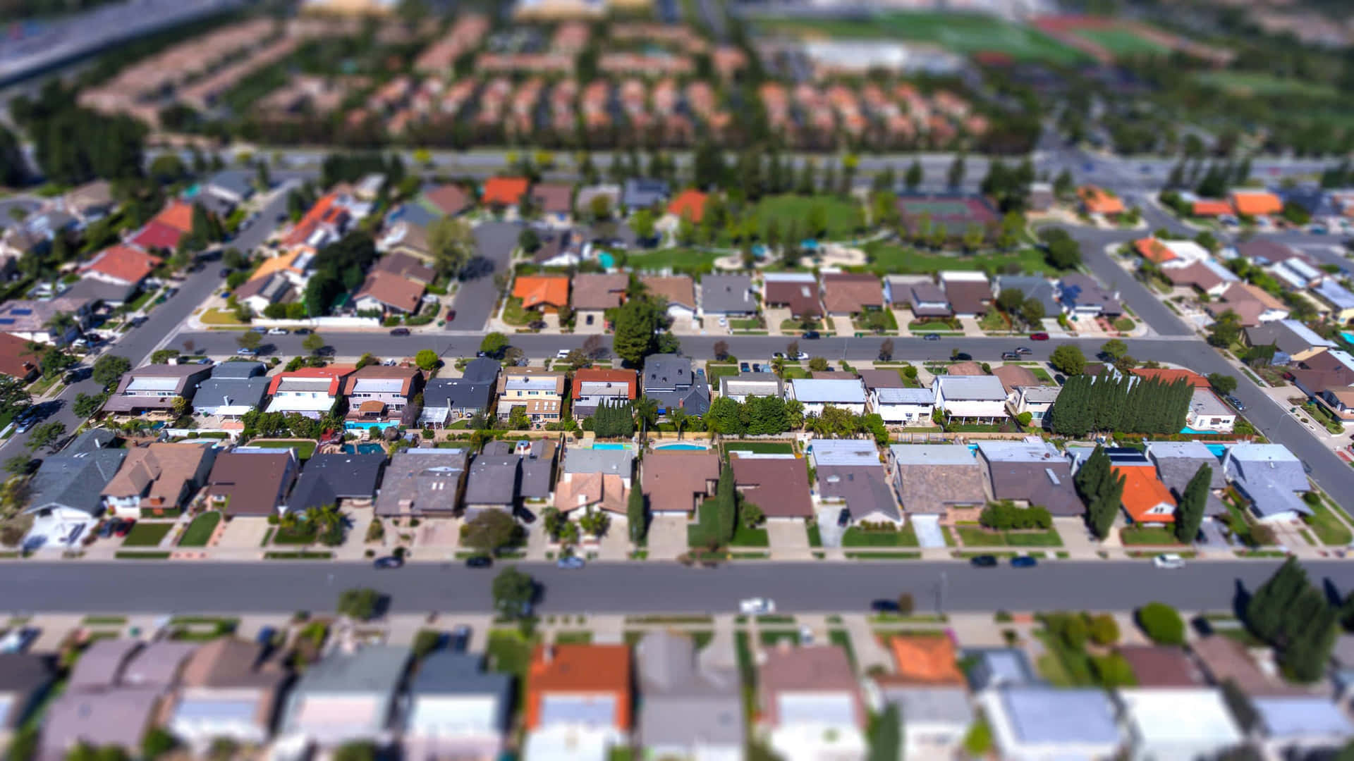 郊區住宅區的空中傾斜移位照片，有房屋和街道。