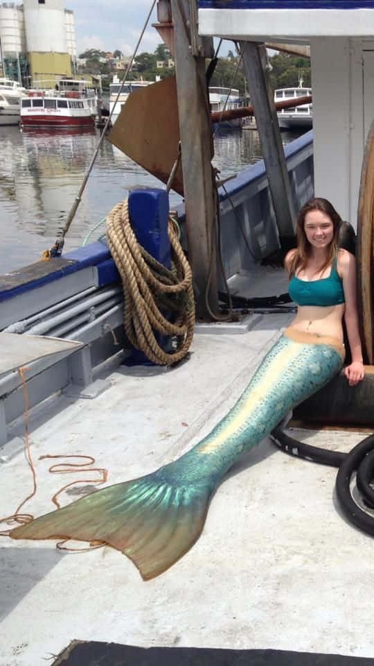 穿著美人魚尾巴的女性坐在船上