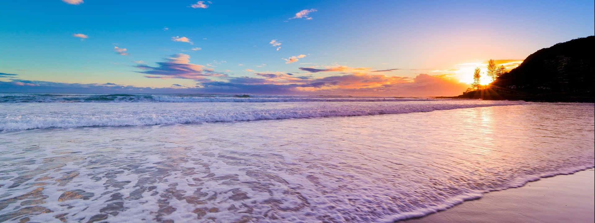 夕陽下的海洋，海浪沖刷沙灘