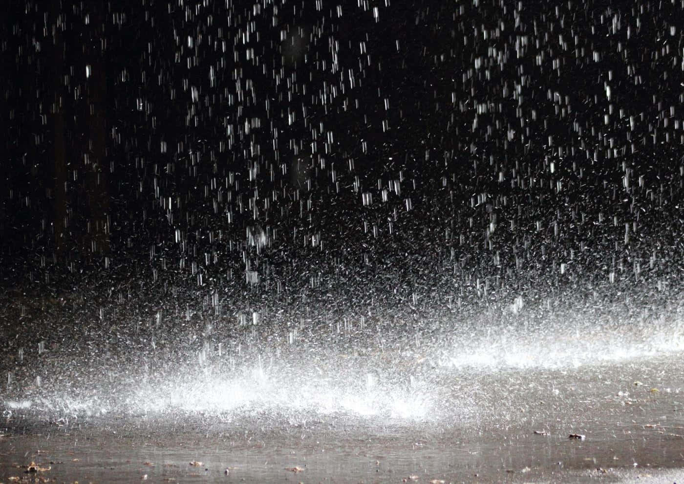夜間雨滴落在潮濕表面並濺起水花。