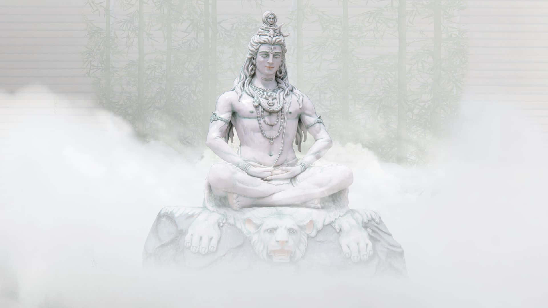 Shiva 桌布 壁紙 — 在霧氣瀰漫的竹林中，一尊寧靜的白色石雕濕婆神在獅子上冥想。