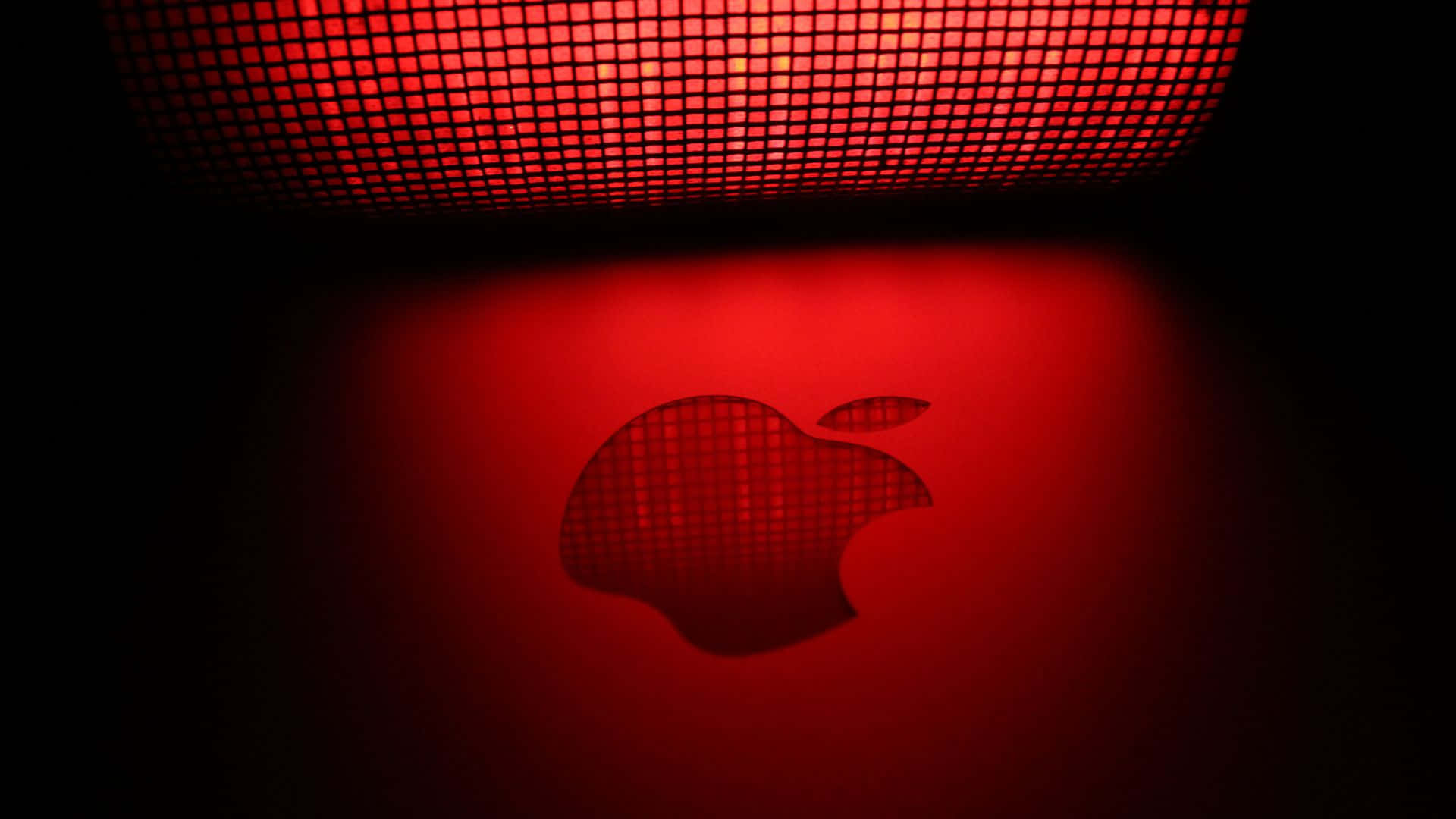 蘋果標誌 桌布 壁紙 — 在黑暗中，一個發光的紅色Apple標誌在網格圖案光源下投射為陰影。