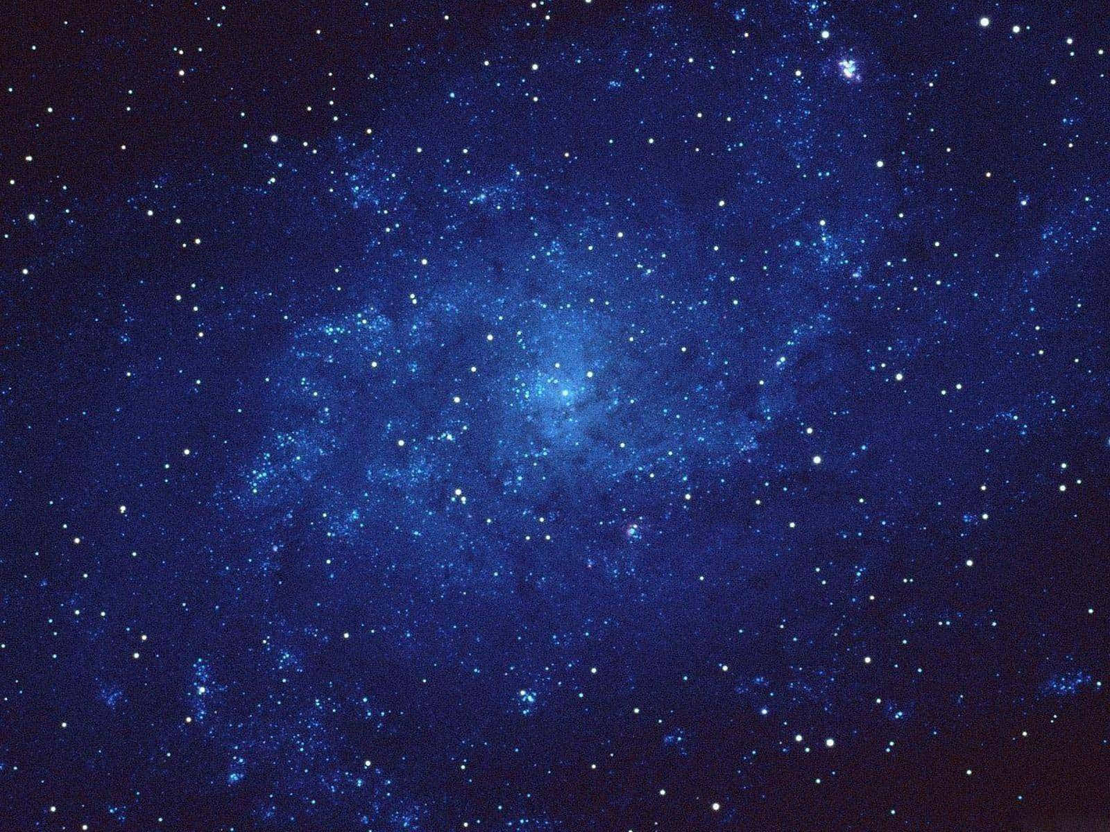 星空 桌布 壁紙 — 在黑暗宇宙背景下，深藍色星雲閃爍著散落星光的壯麗景色。