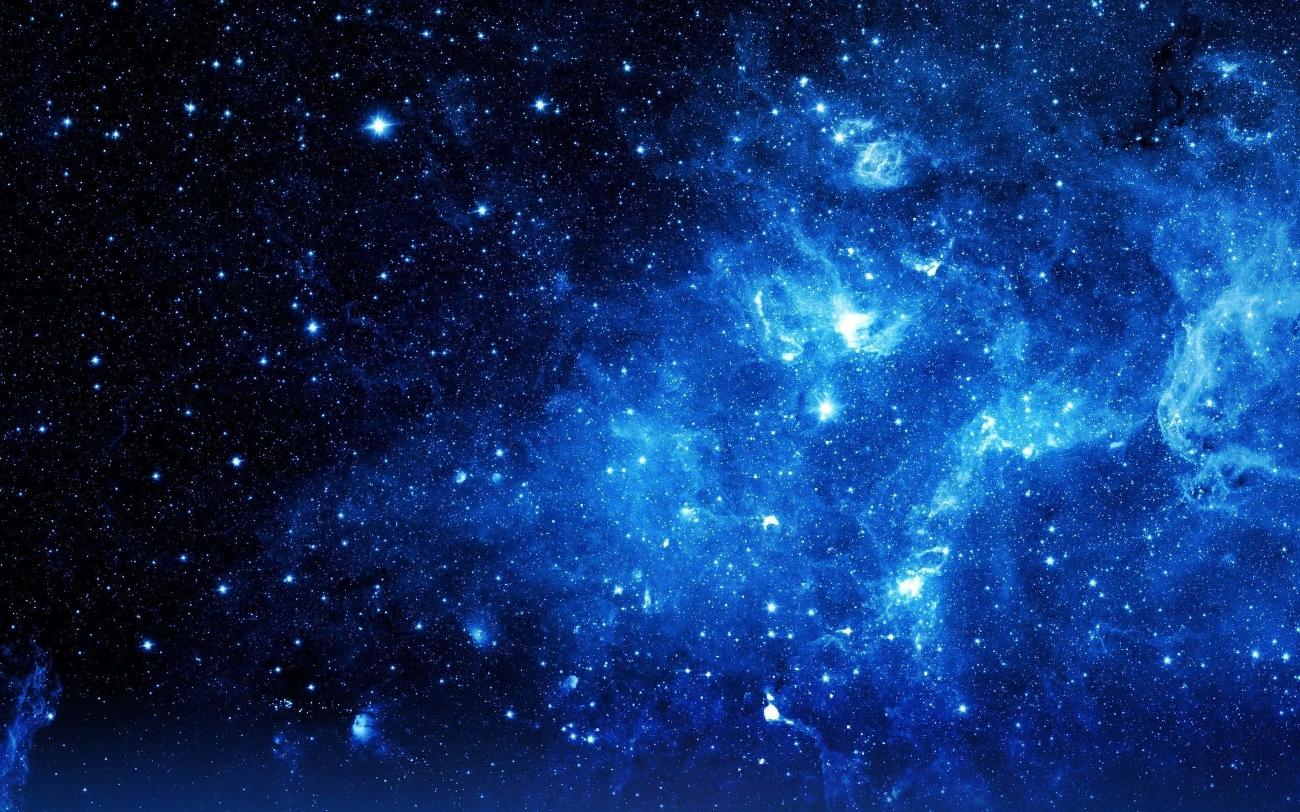Blue Stars 桌布 壁紙 — 在黑暗宇宙背景下，深藍色星雲閃爍著明亮星星的壯麗景色。