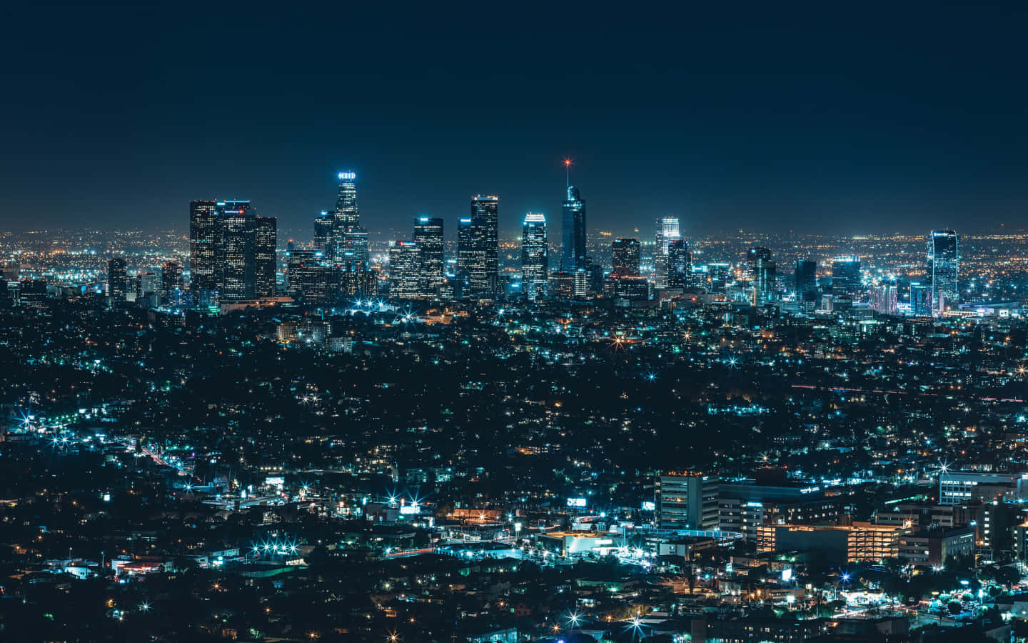 La 桌布 壁紙 — 在黑暗的天空下，一個廣闊的城市夜景，閃爍的摩天大樓和密集的社區。
