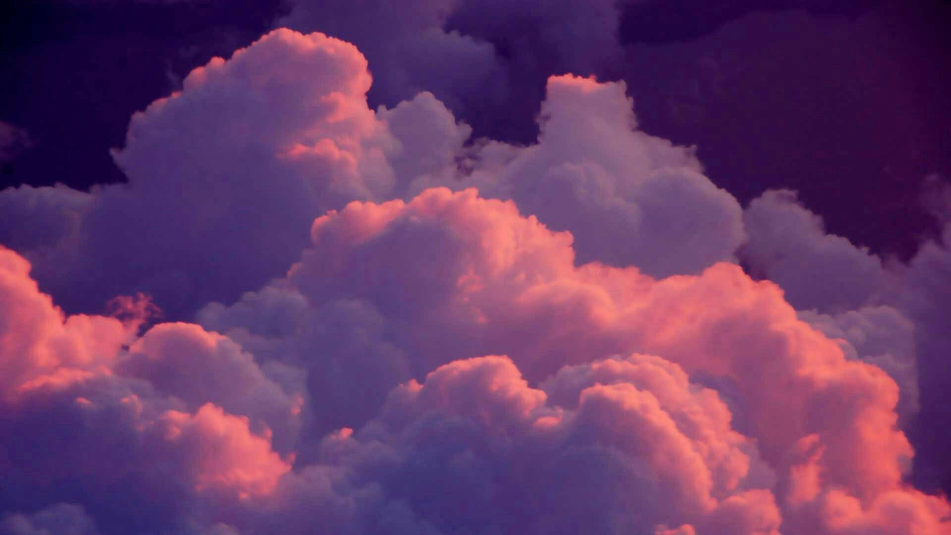 唯美雲朵動態 桌布 壁紙 — 在黑暗的暮色天空中，豐盈的雲朵散發出火紅的粉紅色和深紫色的色調。