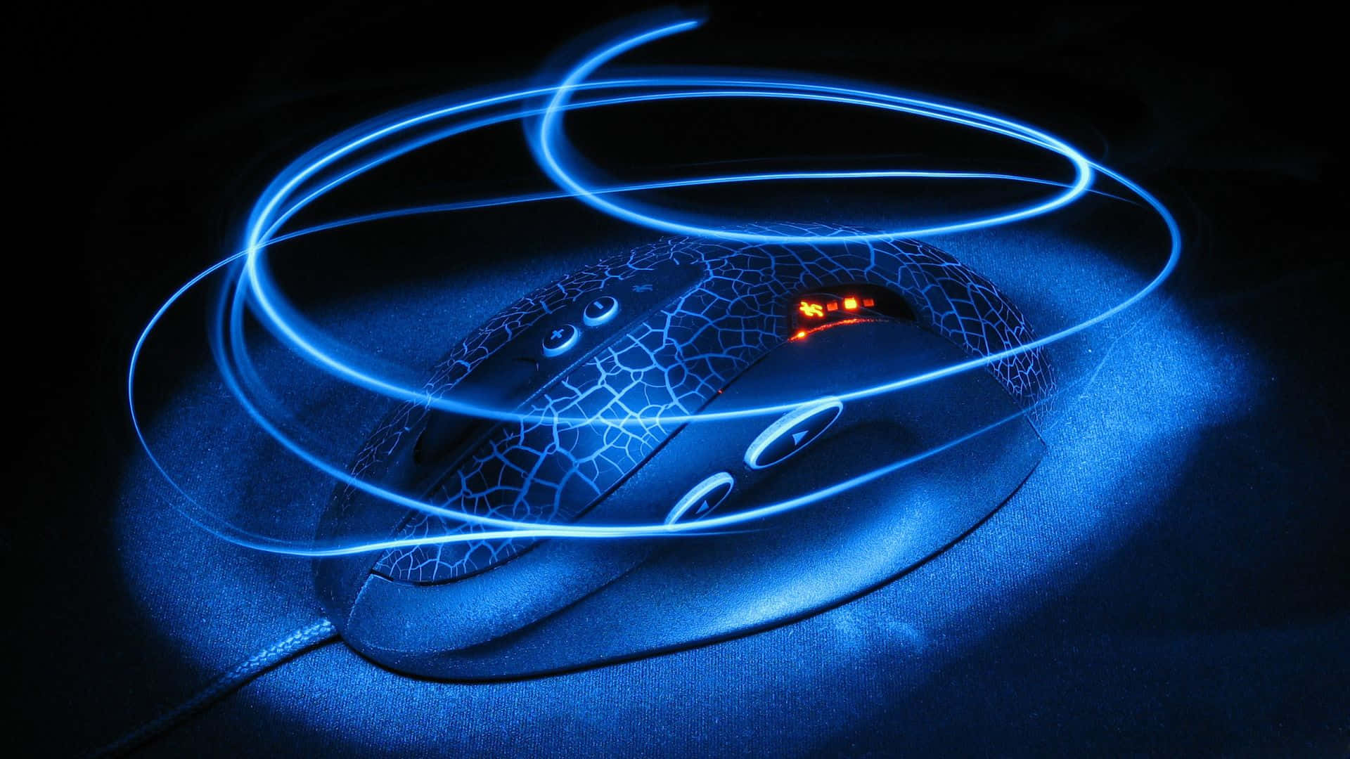 Gaming Mice 桌布 壁紙 — 在黑暗表面上，帶有發光藍色光跡環繞的遊戲滑鼠。