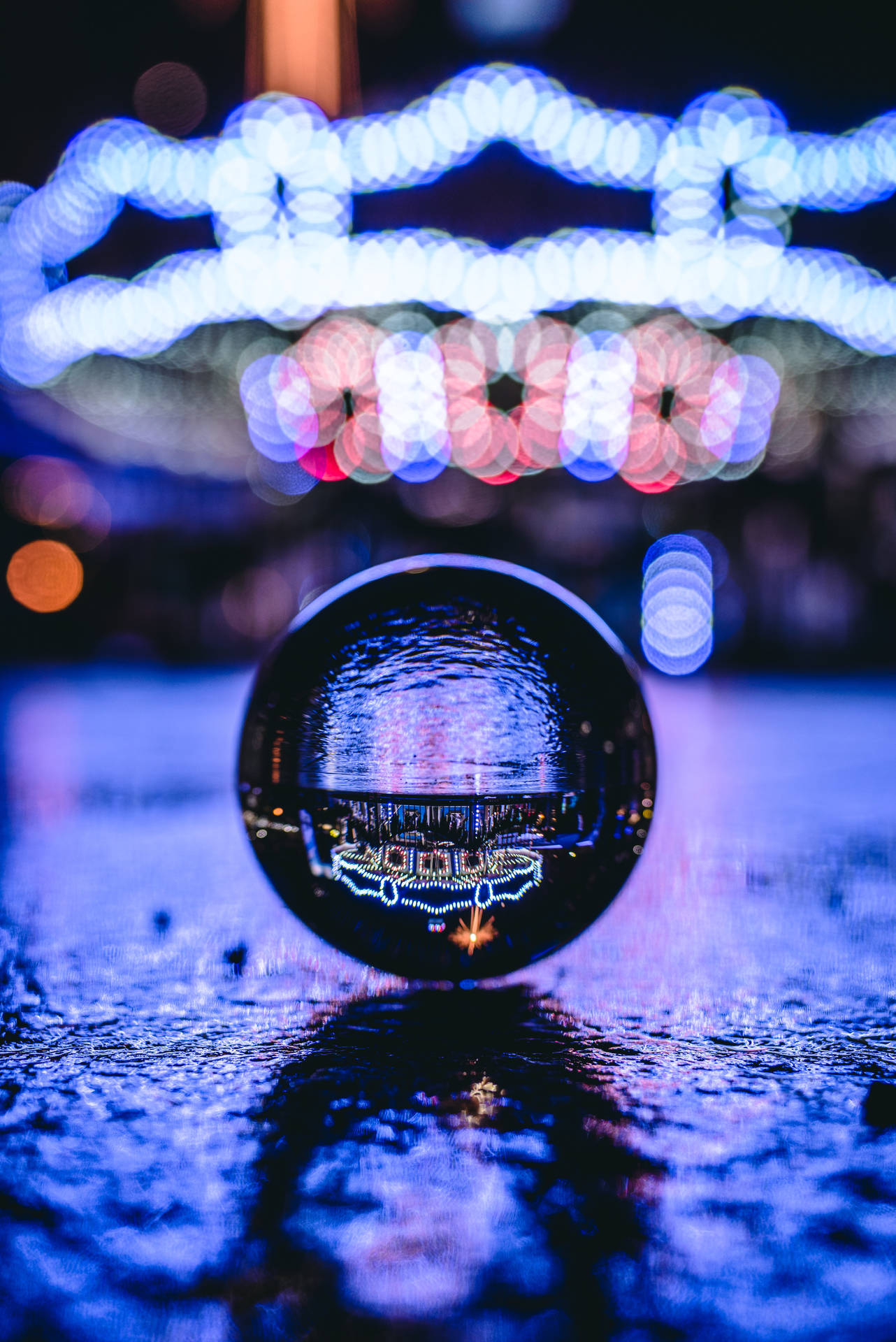 玻璃球在夜間濕漉漉的路面上反射城市燈光。