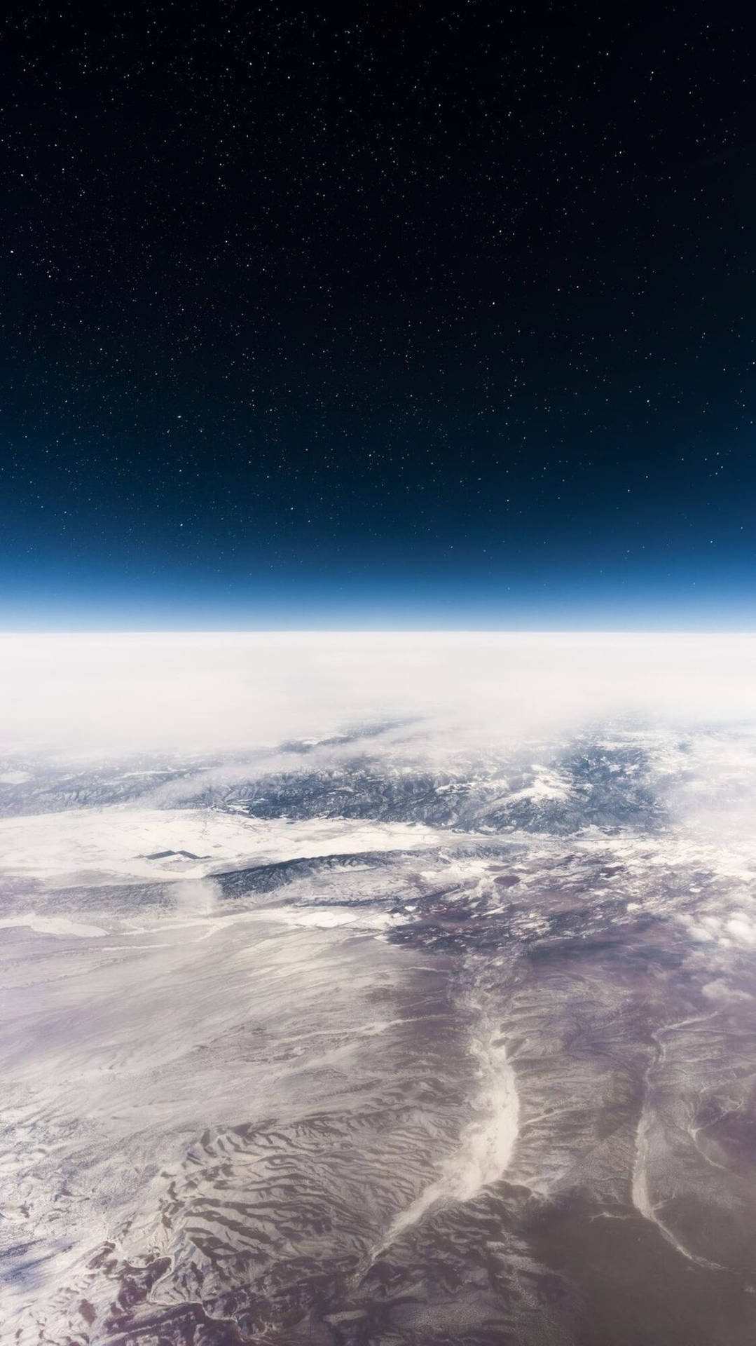從太空看到的地球，雪雲和地形上方有星星。 — 主螢幕 壁紙