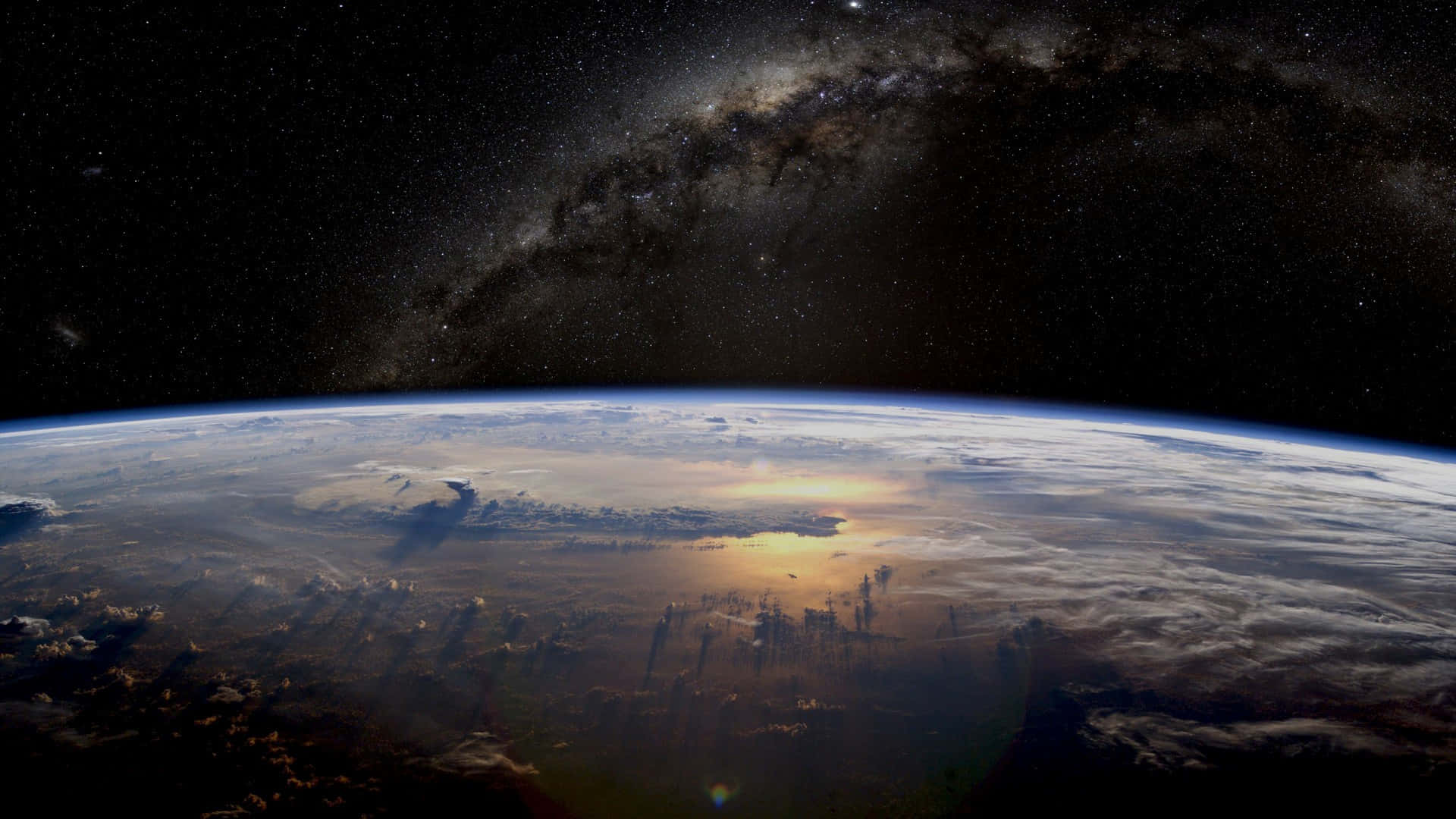 Galaxy Poster 桌布 壁紙 — 地球在星空下彎曲，銀河系在雲層覆蓋的大地上方拱起。
