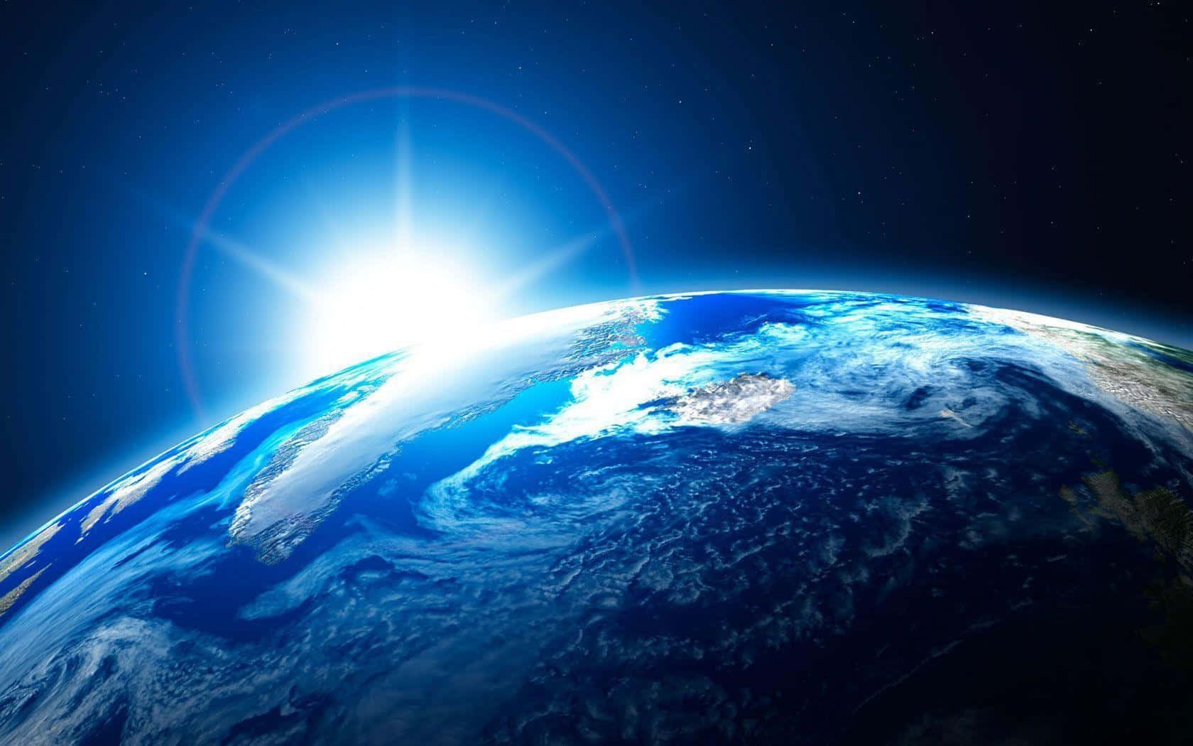 Blue Planet 桌布 壁紙 — 地球在繁星點點的虛空中雄偉地彎曲，一輪燦爛的太陽在其地平線後方燃燒。