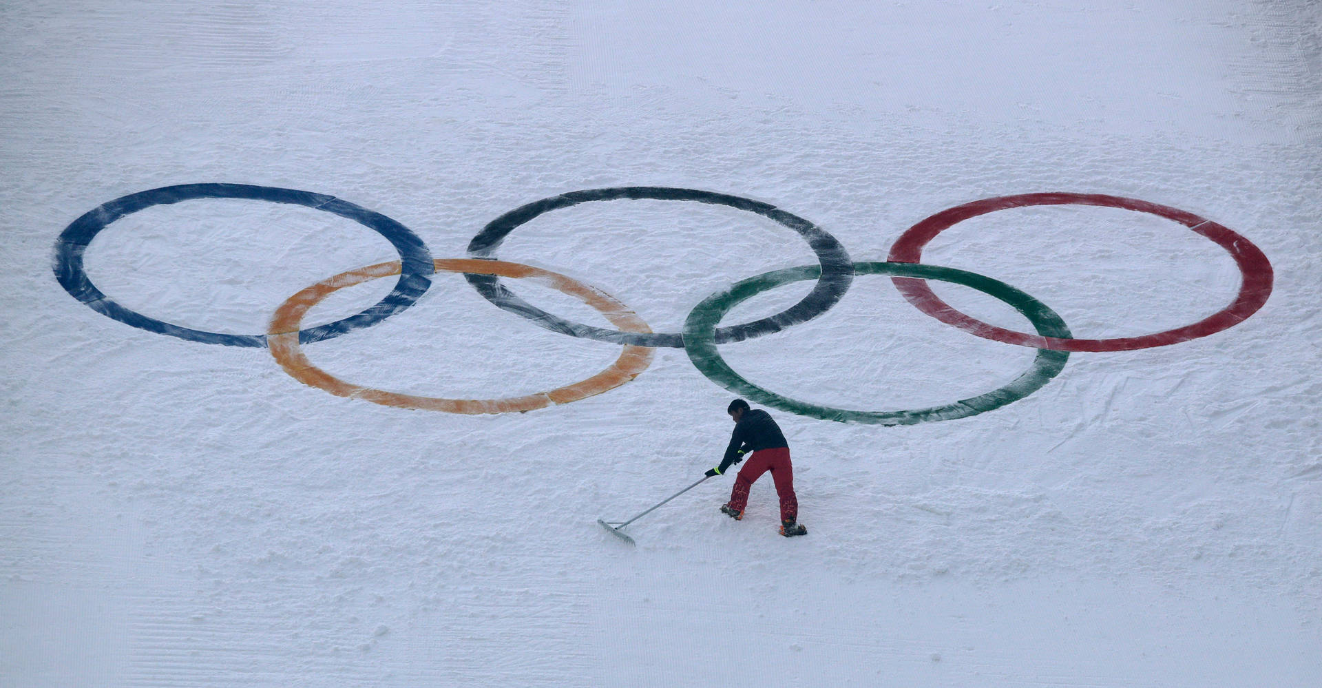 工人在冬季運動場地整理奧運五環周圍的積雪。