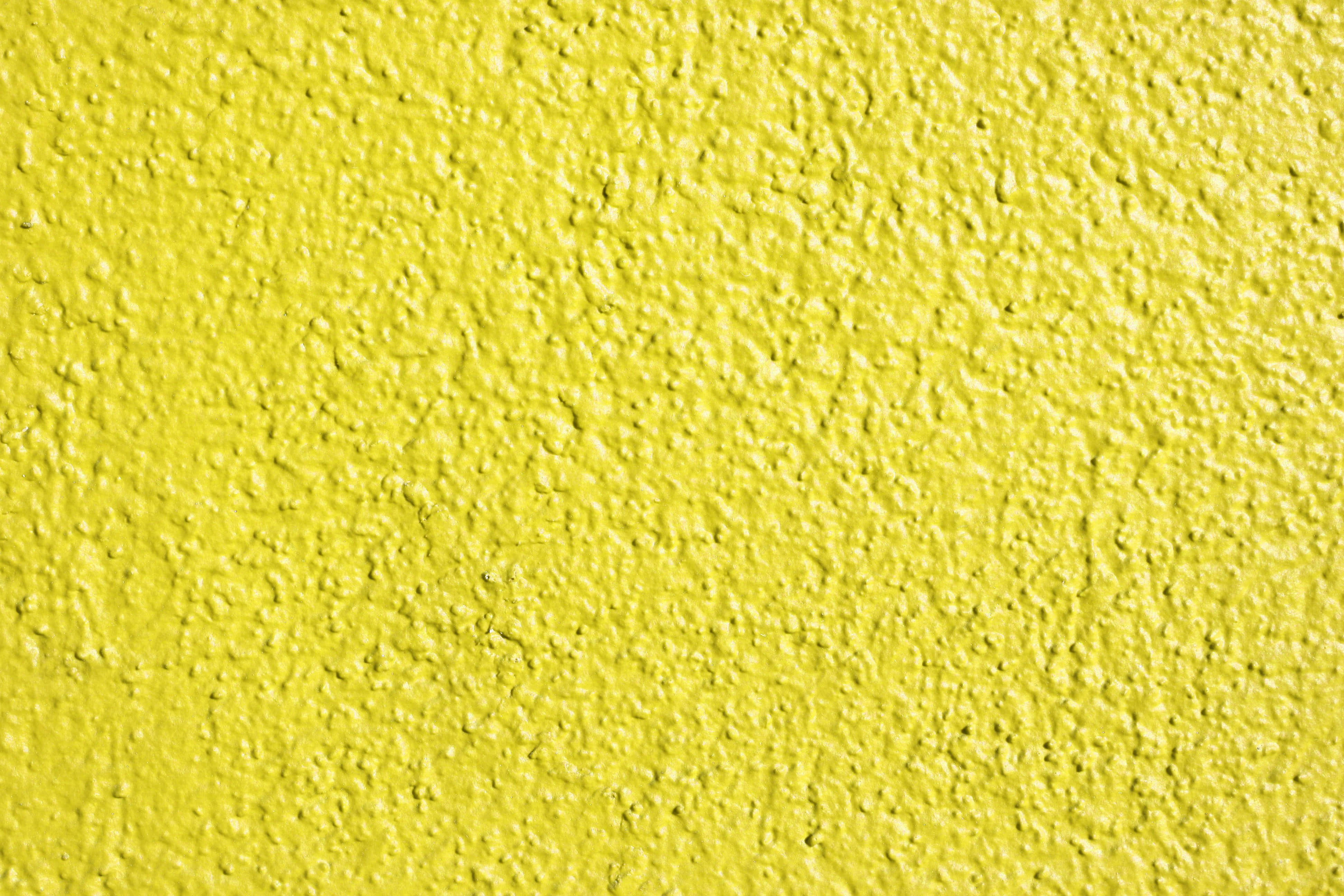 Paint Texture 桌布 壁紙 — 均勻光線下粗糙灰泥飾面嘅鮮黃色紋理牆壁特寫。
