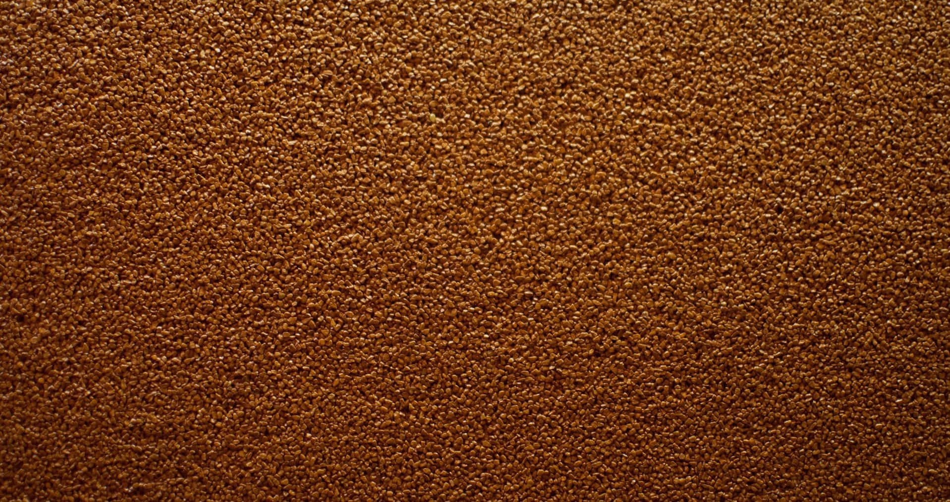 Brown Texture 桌布 壁紙 — 均勻照明下均勻棕色顆粒的密集紋理表面特寫。