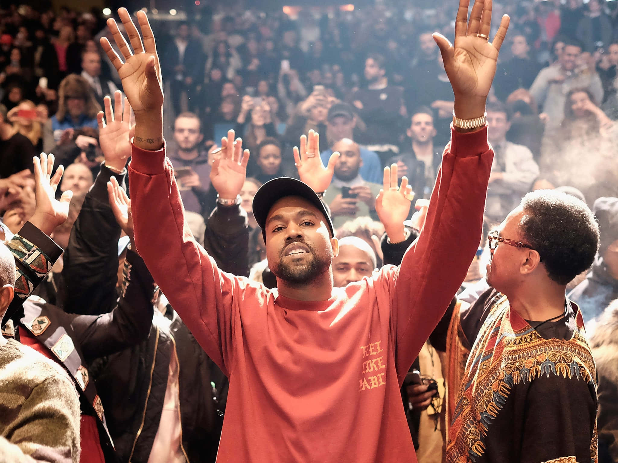 坎耶·威斯特《The Life Of Pablo》專輯藝術圖 壁紙 — Kanye West 在演唱會中於人群中舉起雙手，粉絲歡呼並舉起手機。