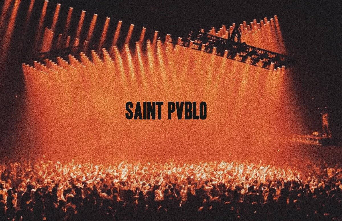 橙色舞台燈光下的演唱會人群和 'SAINT PVBLO' 文字。