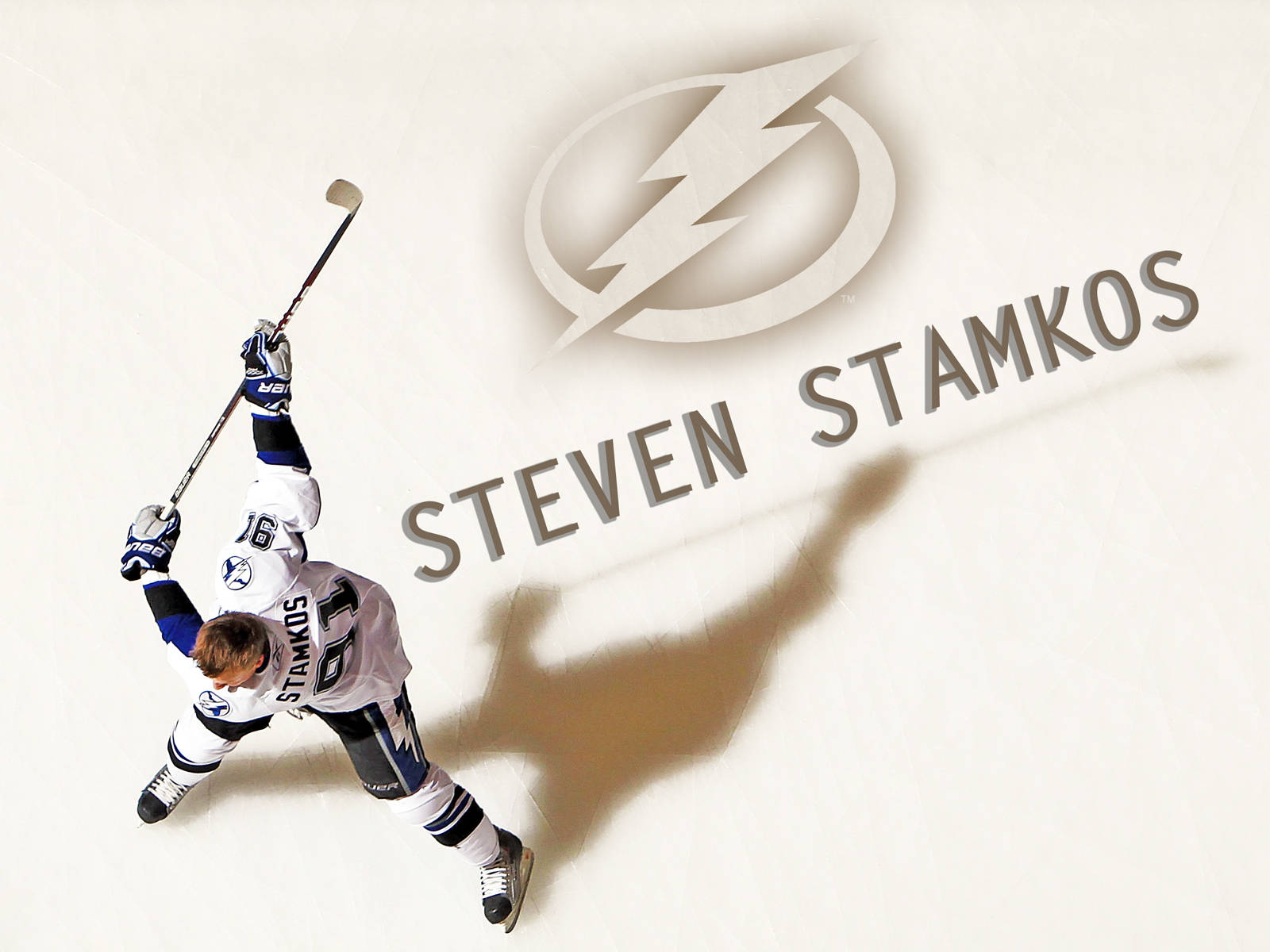 坦帕灣光芒隊之星——史蒂文·史塔科斯冰場英姿 壁紙 — 冰球運動員 Steven Stamkos 身穿白色球衣在冰場上凌空躍起，身後投射出球隊標誌和名字的陰影。