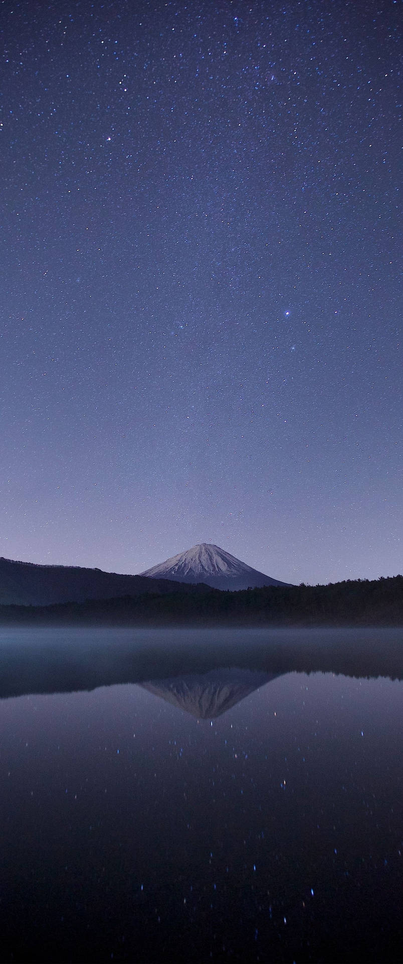 富士山在星空下倒映在湖面上。