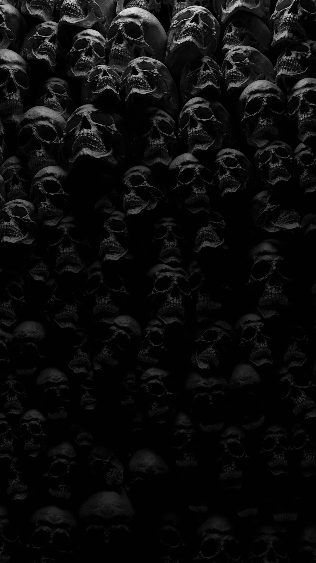黑色同灰色色調中密集排列嘅人類頭骨Wallpaper。