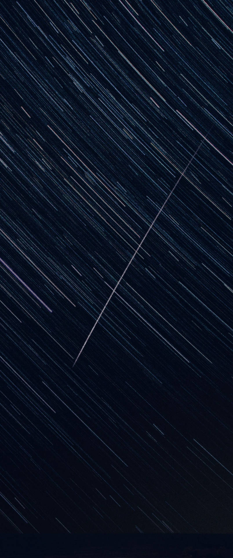 黑暗夜空中的長曝光星軌，帶有對角線光條。