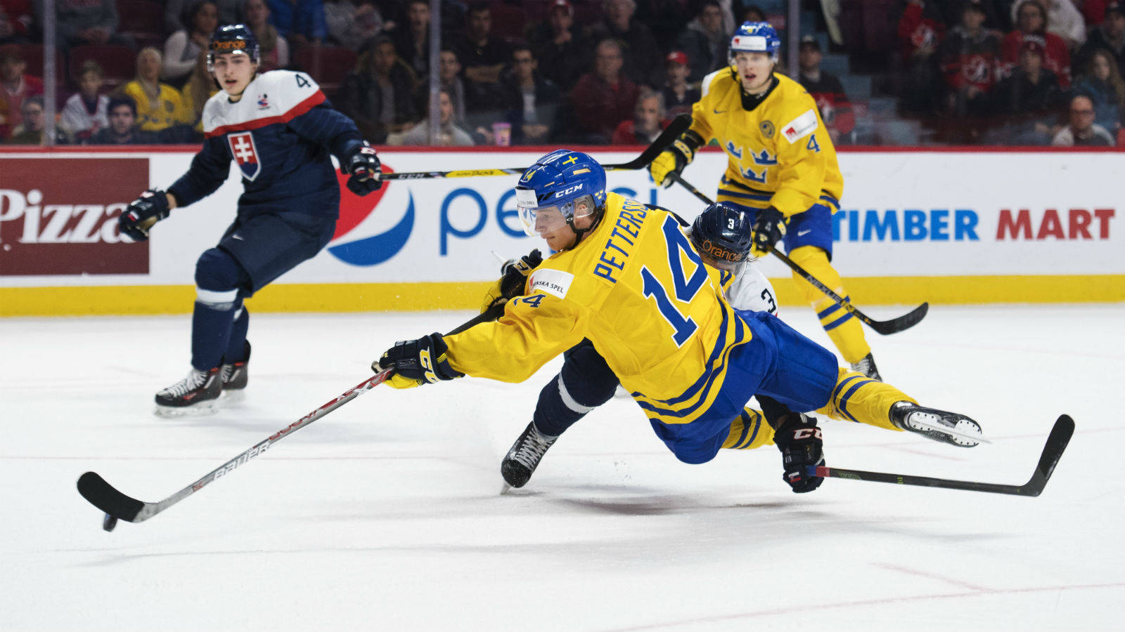 埃利亞斯·佩特ters森——NHL知名14號球員 壁紙 — 一名身穿黃色球衣的冰球運動員在冰上低身飛撲，對手在緊張的比賽中從後追趕。