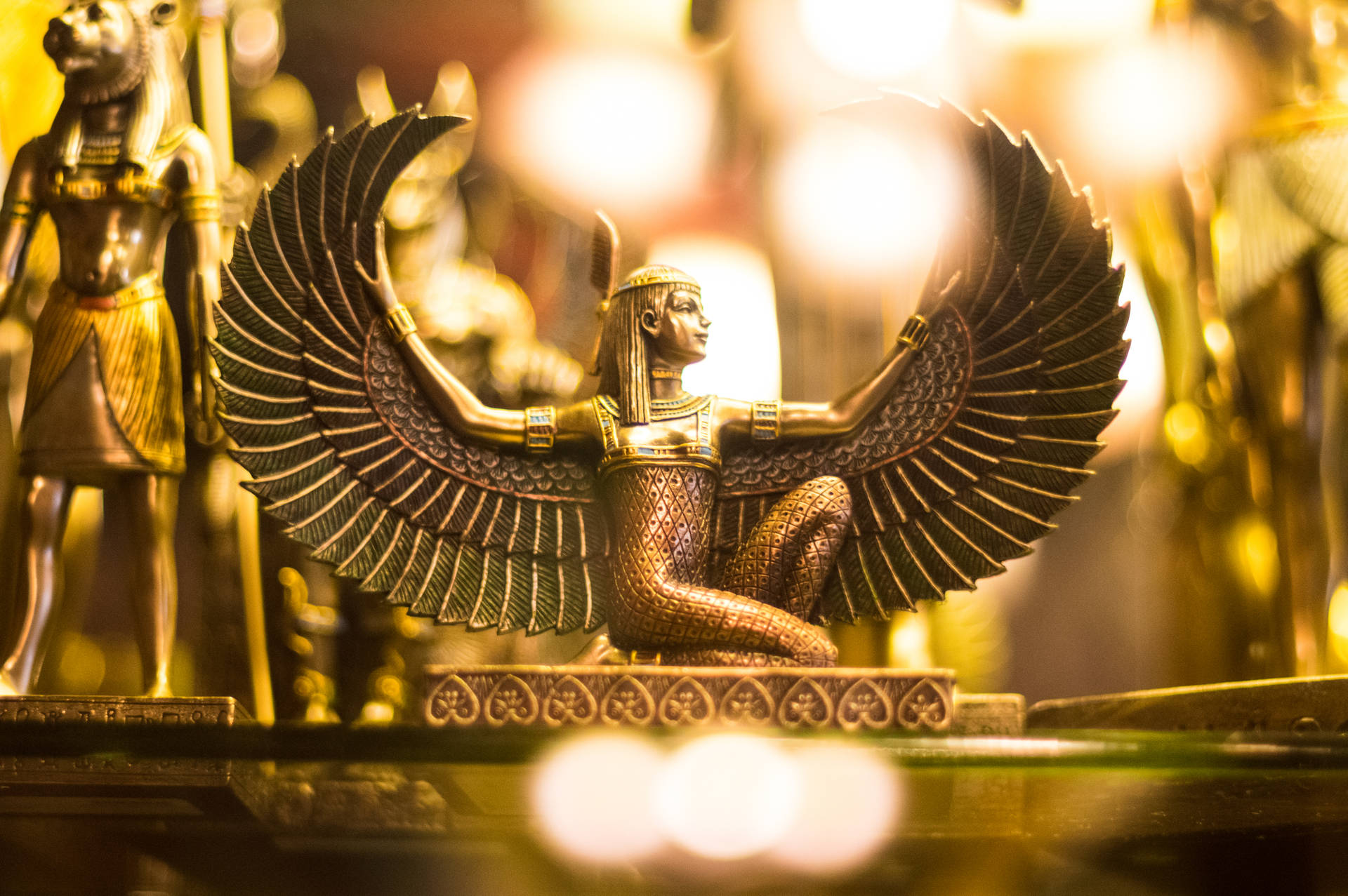 金色埃及女神雕像，在溫暖的博物館燈光下翅膀抬起。