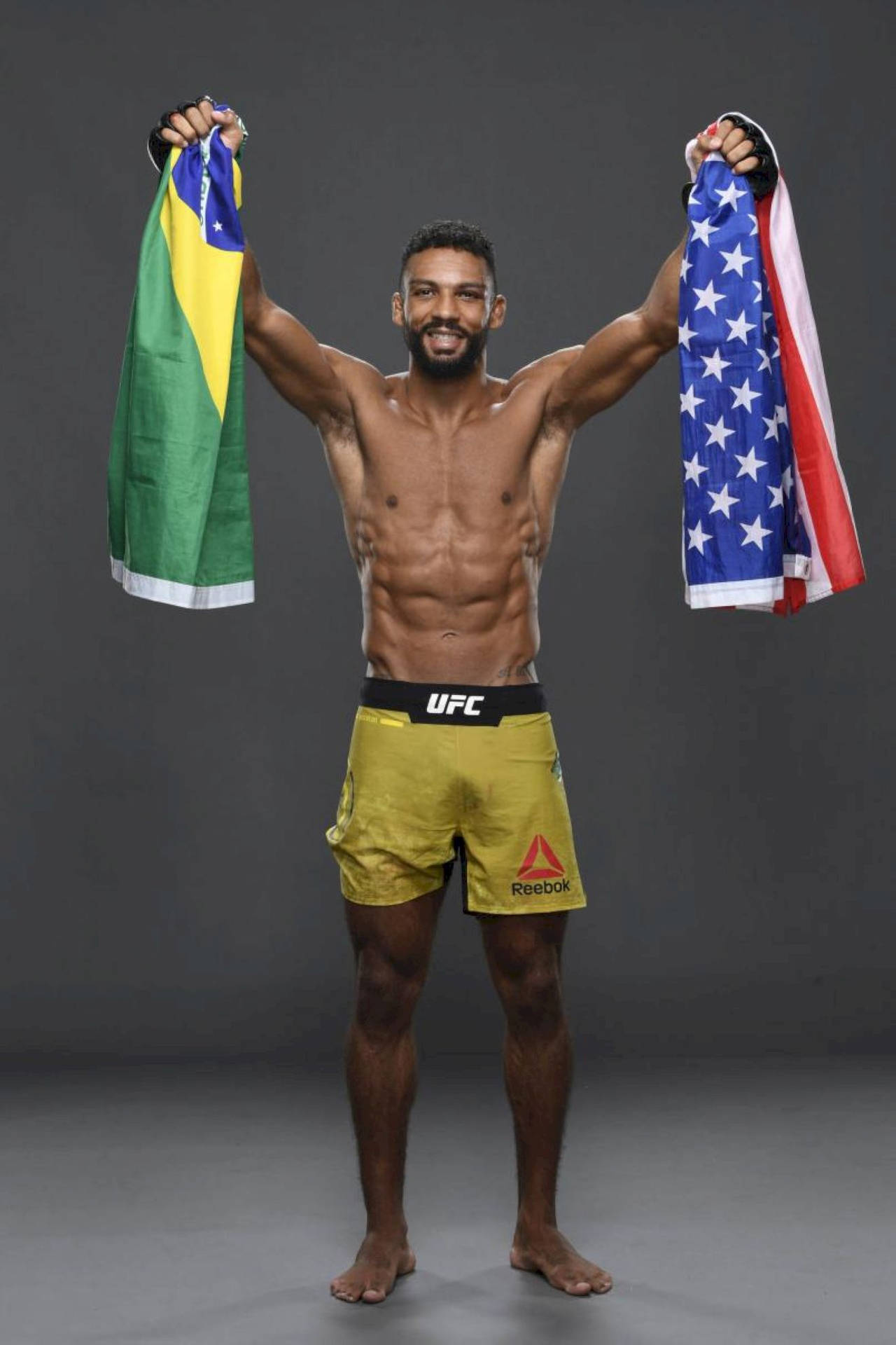 UFC拳手以勝利姿勢高舉巴西和美國國旗。