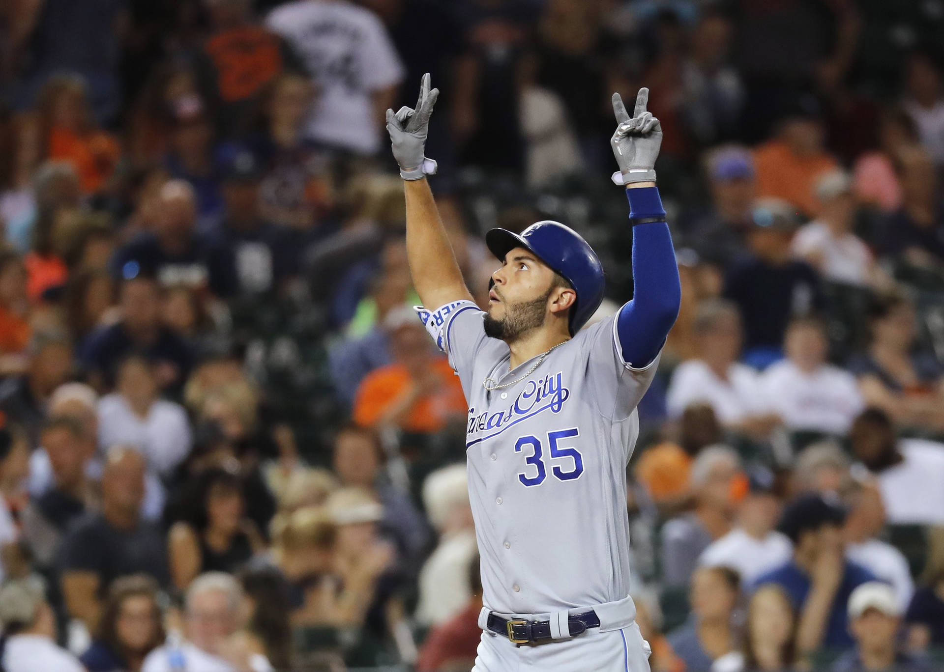 棒球選手在夜間比賽中高舉雙手慶祝勝利。