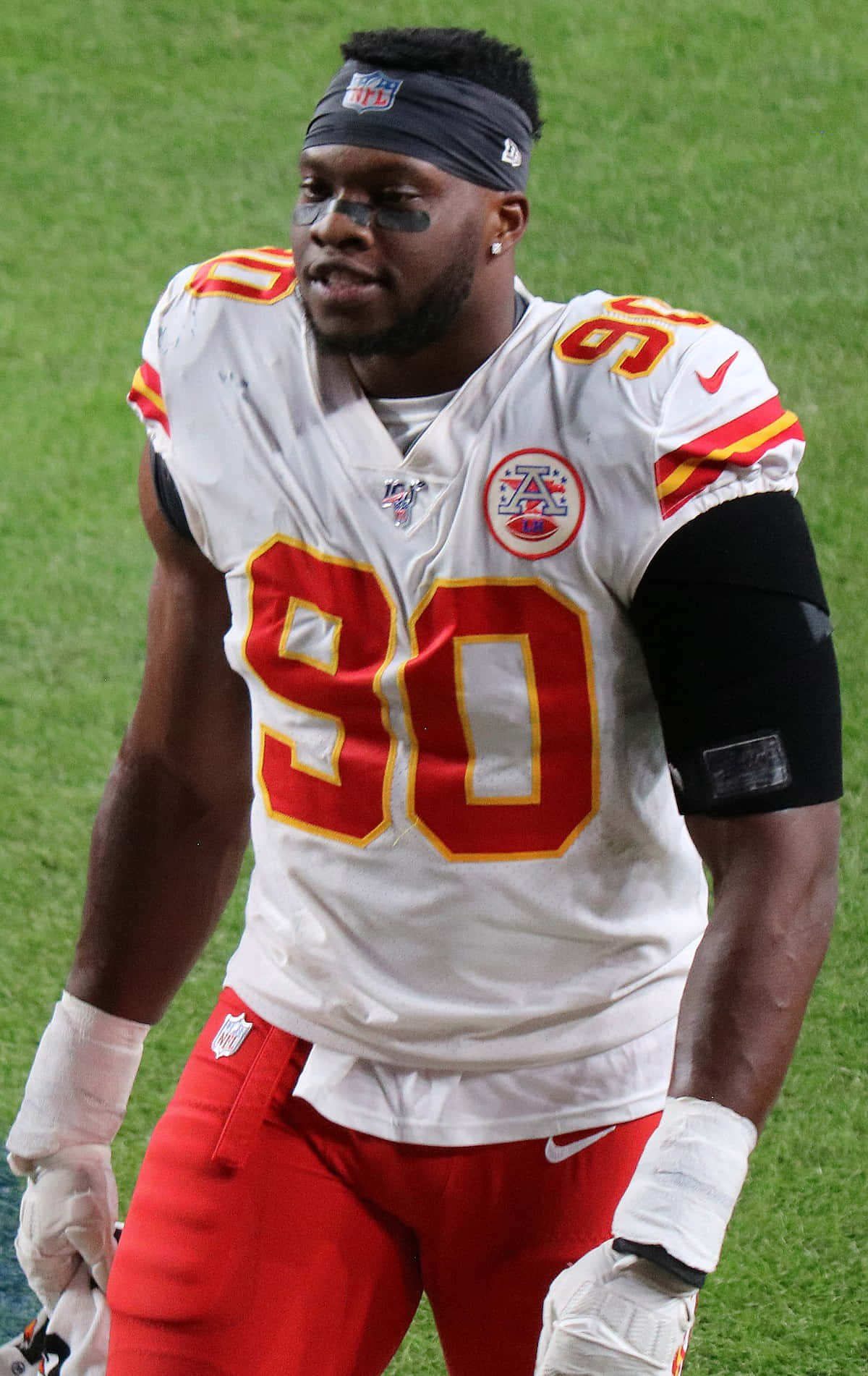 埃馬努埃爾·奧格巴90號球衣 壁紙 — 一位專注的NFL防守端鋒，身穿白色和紅色球衣，號碼90，站在綠色足球場上。