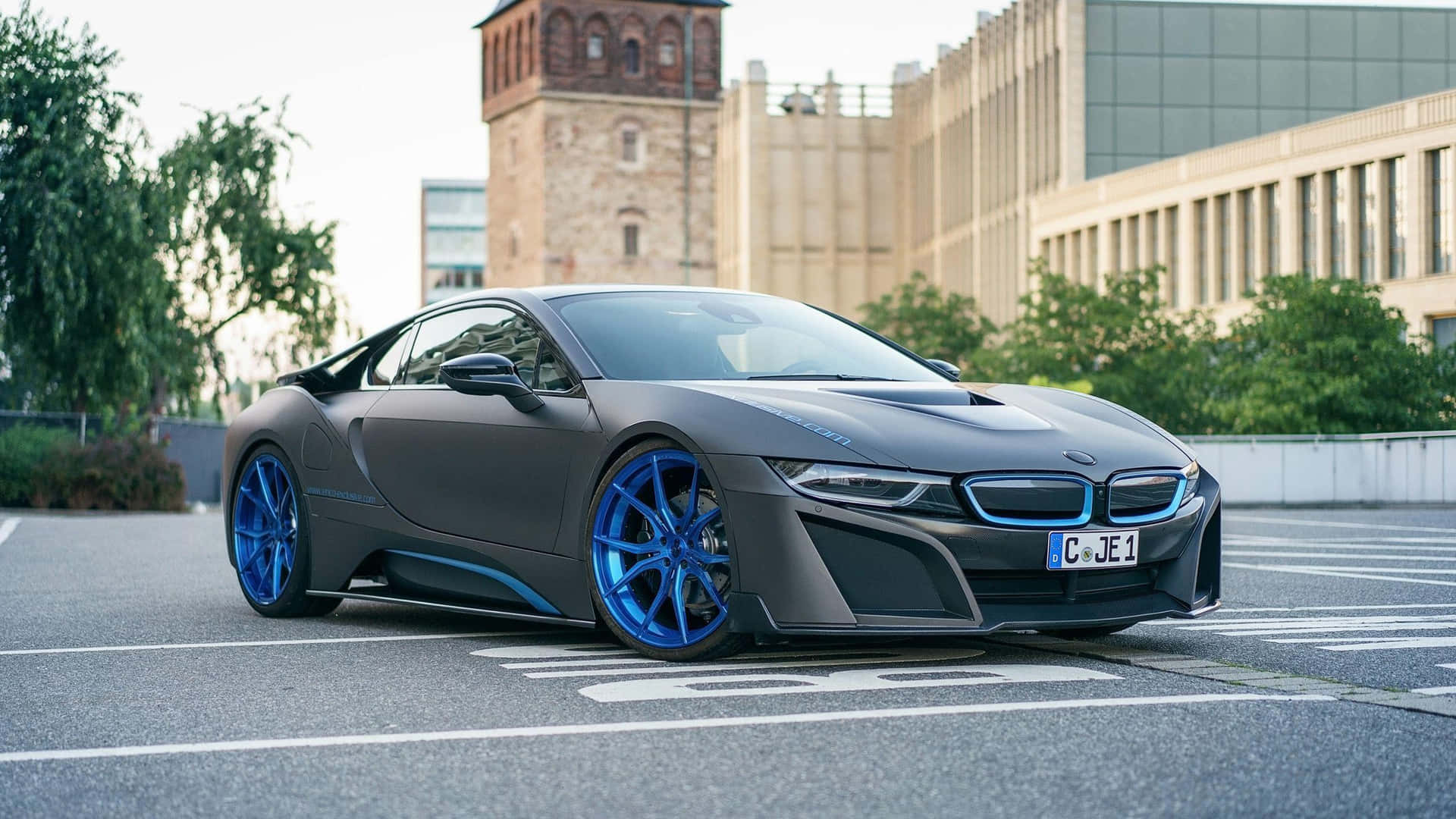 啞光灰色BMW i8配藍色車輪停泊於城市環境中。
