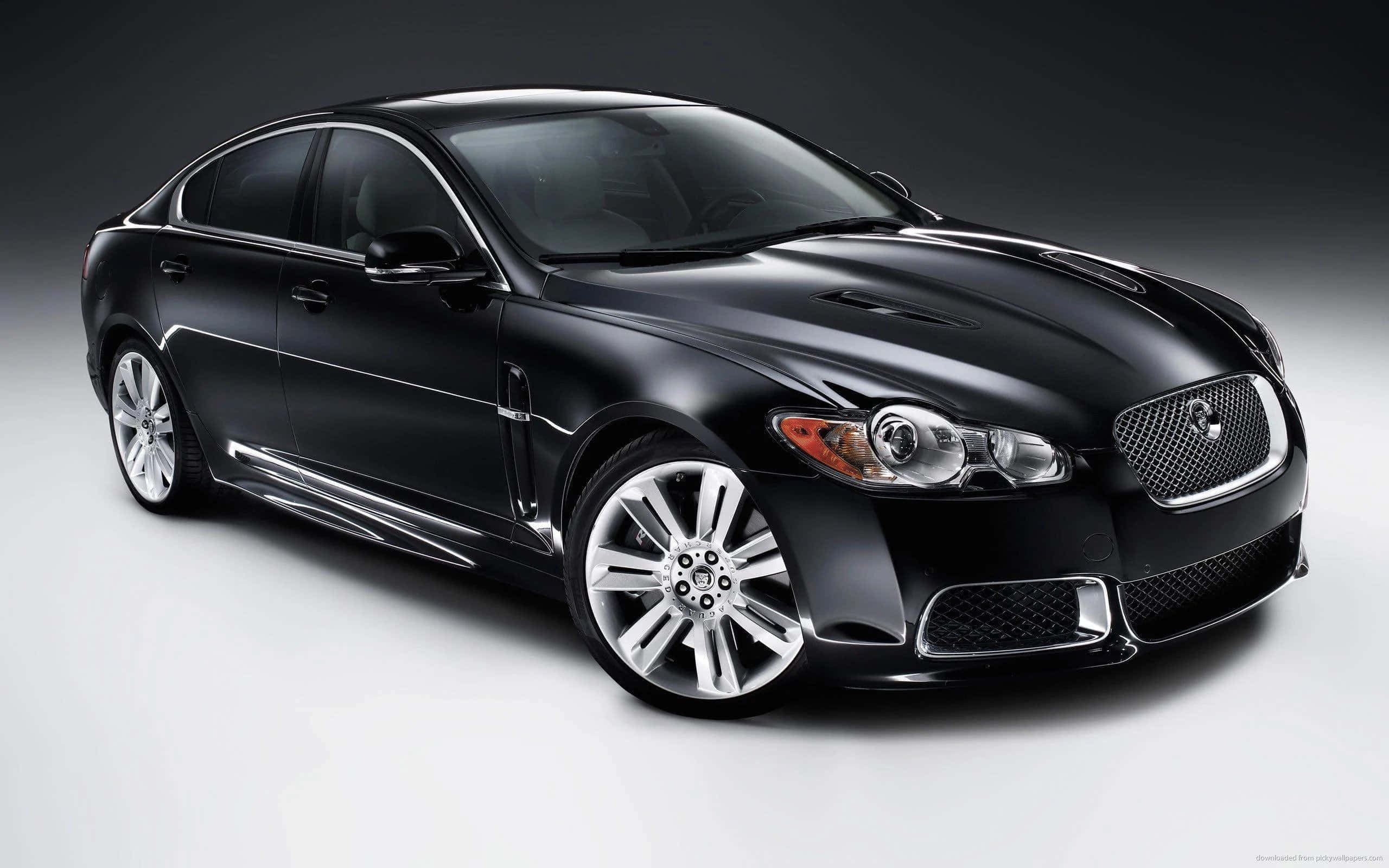 城市中的豪華黑色轎車 壁紙 — 一輛時尚的黑色Jaguar XF轎車在攝影棚燈光下閃耀，配以拋光鍍鉻飾件和進取造型。