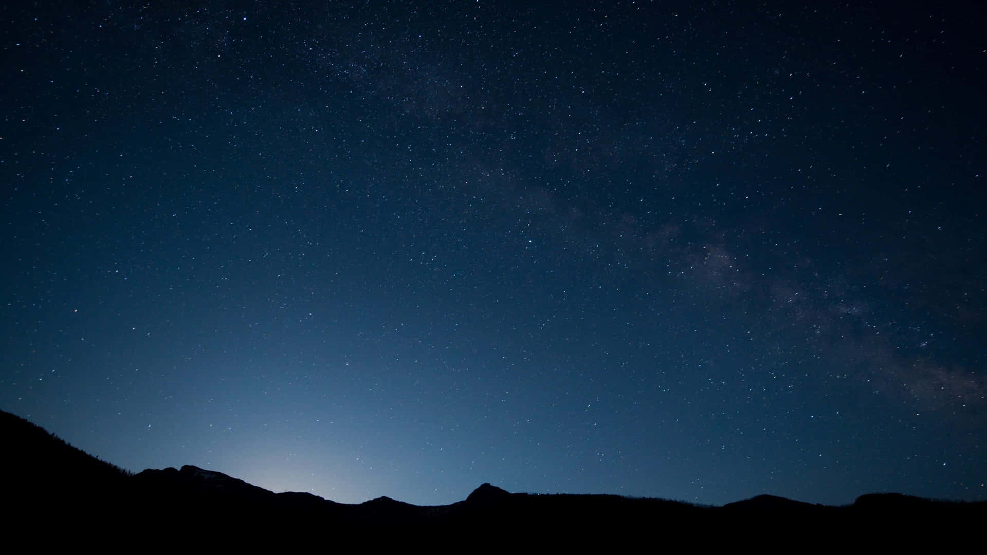 在星空夜空下，可見銀河的剪影山脈。