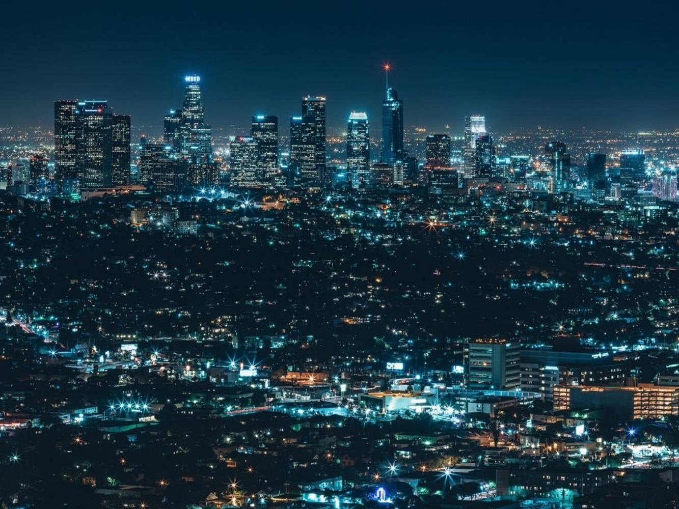 密集城市天際線的夜景，建築物和街道燈火通明。
