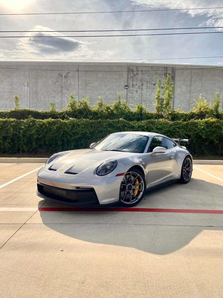 日落時分停泊在停車場的銀色保時捷911 GT3。