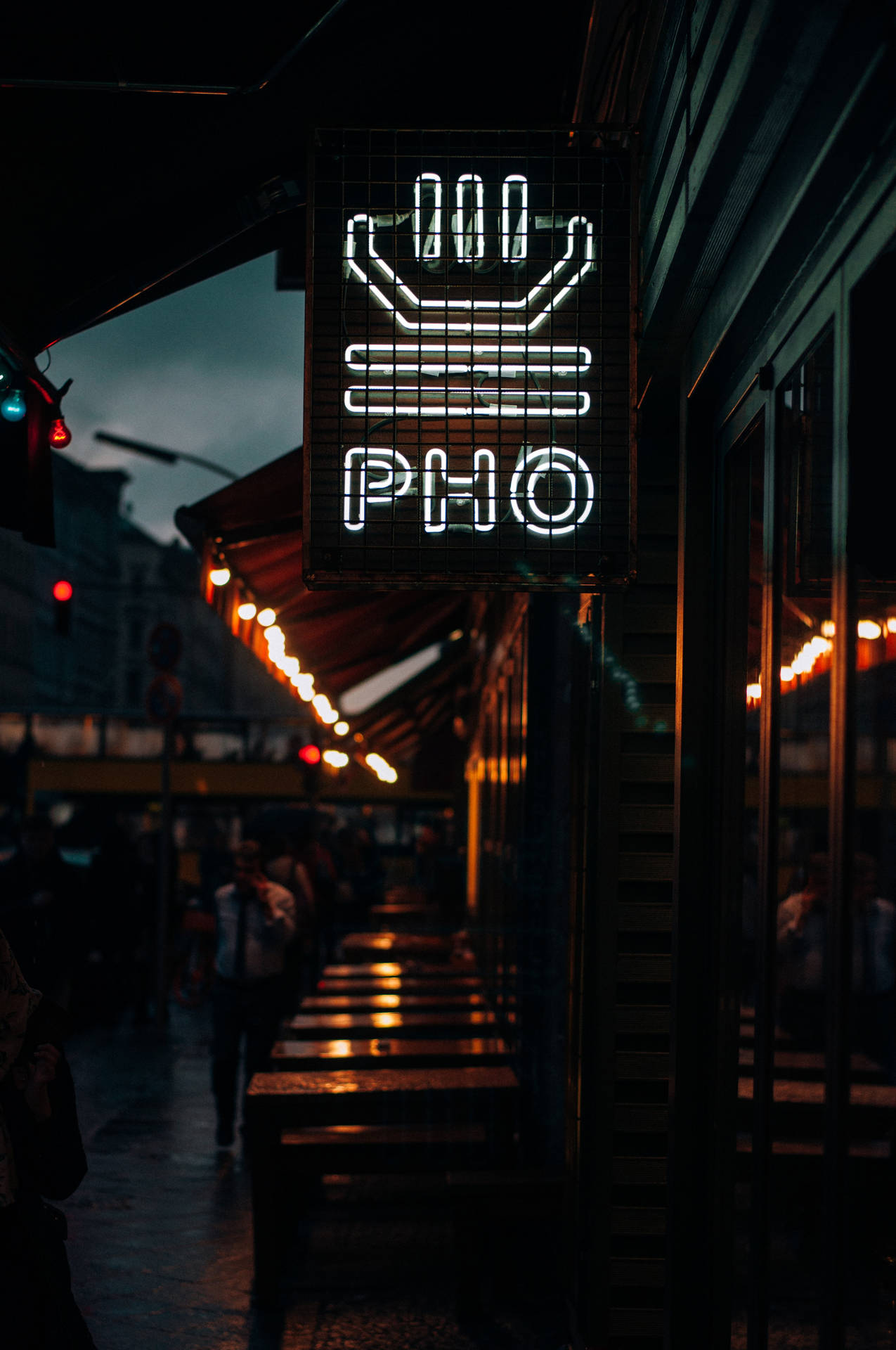 夜晚城市街道上，發光的手形霓虹燈越南河粉餐廳招牌。