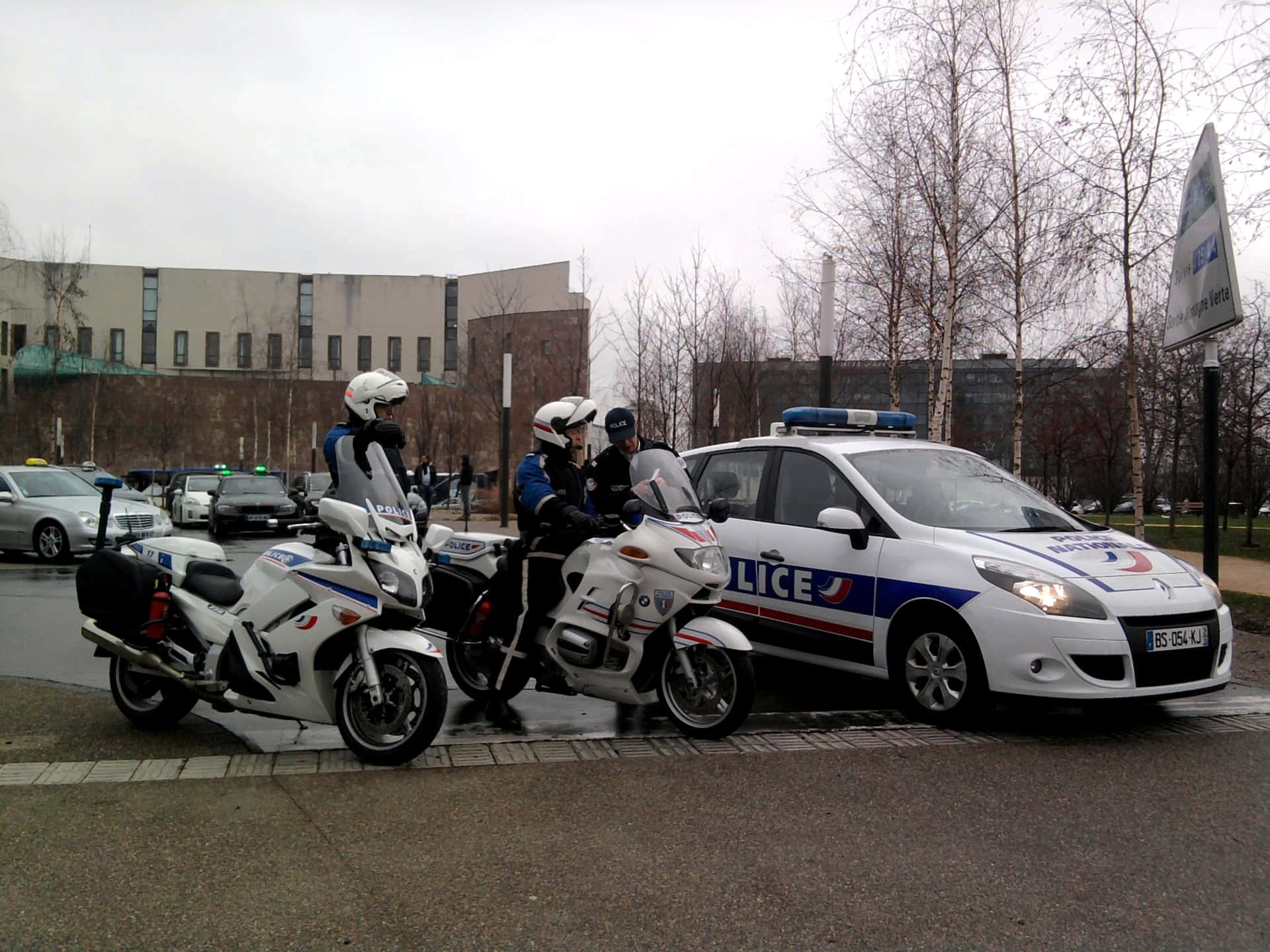 警察與電單車及汽車在濕漉漉的城市行人路上