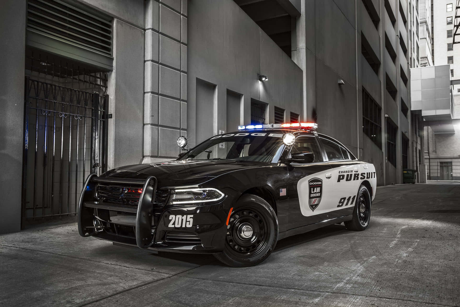 夜晚城市小巷中停著一輛閃著警燈的黑白警車。