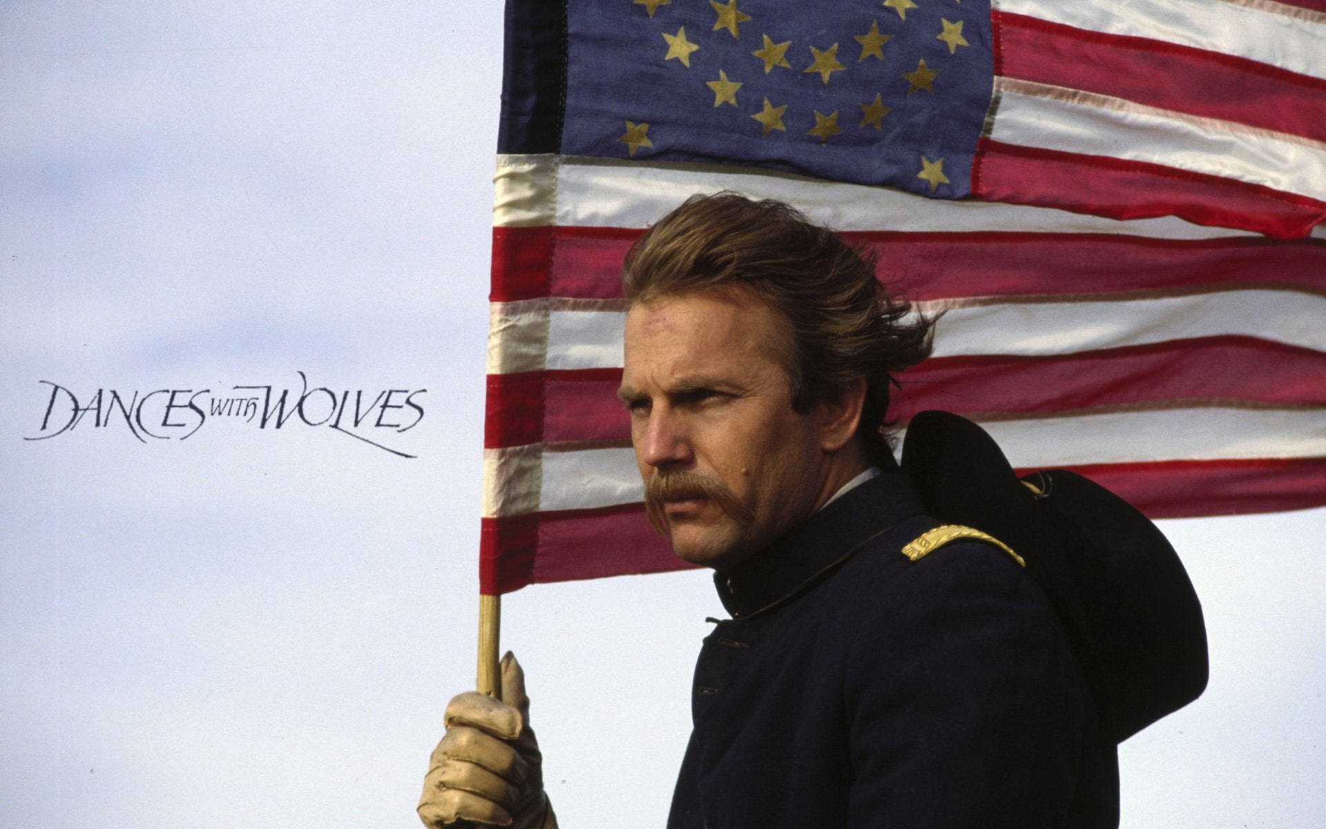 身穿藍色制服的士兵舉著美國國旗，電影標題 DANCES WITH WOLVES。