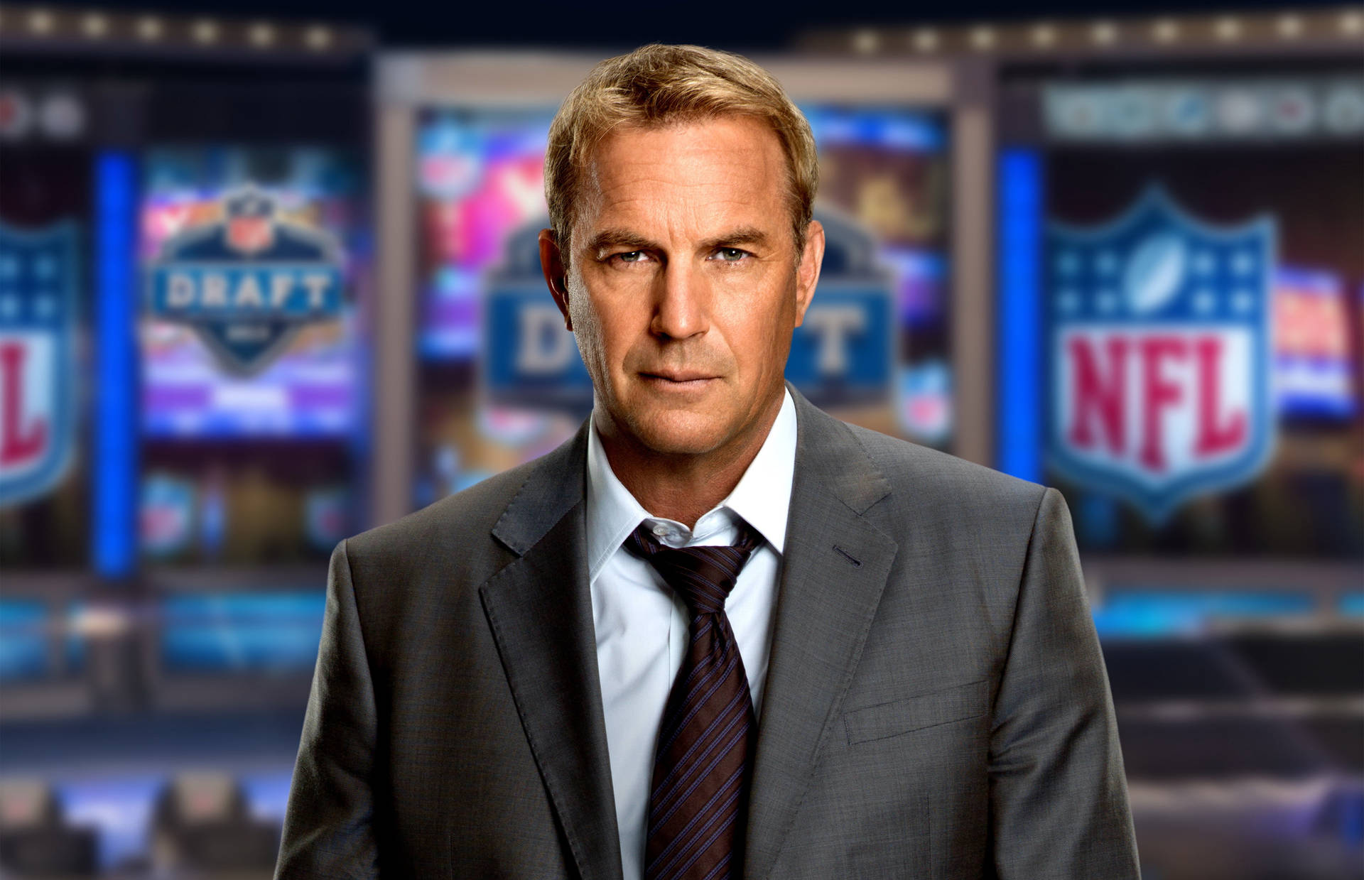 在NFL選秀轉播工作室中穿著西裝和領帶的男子。