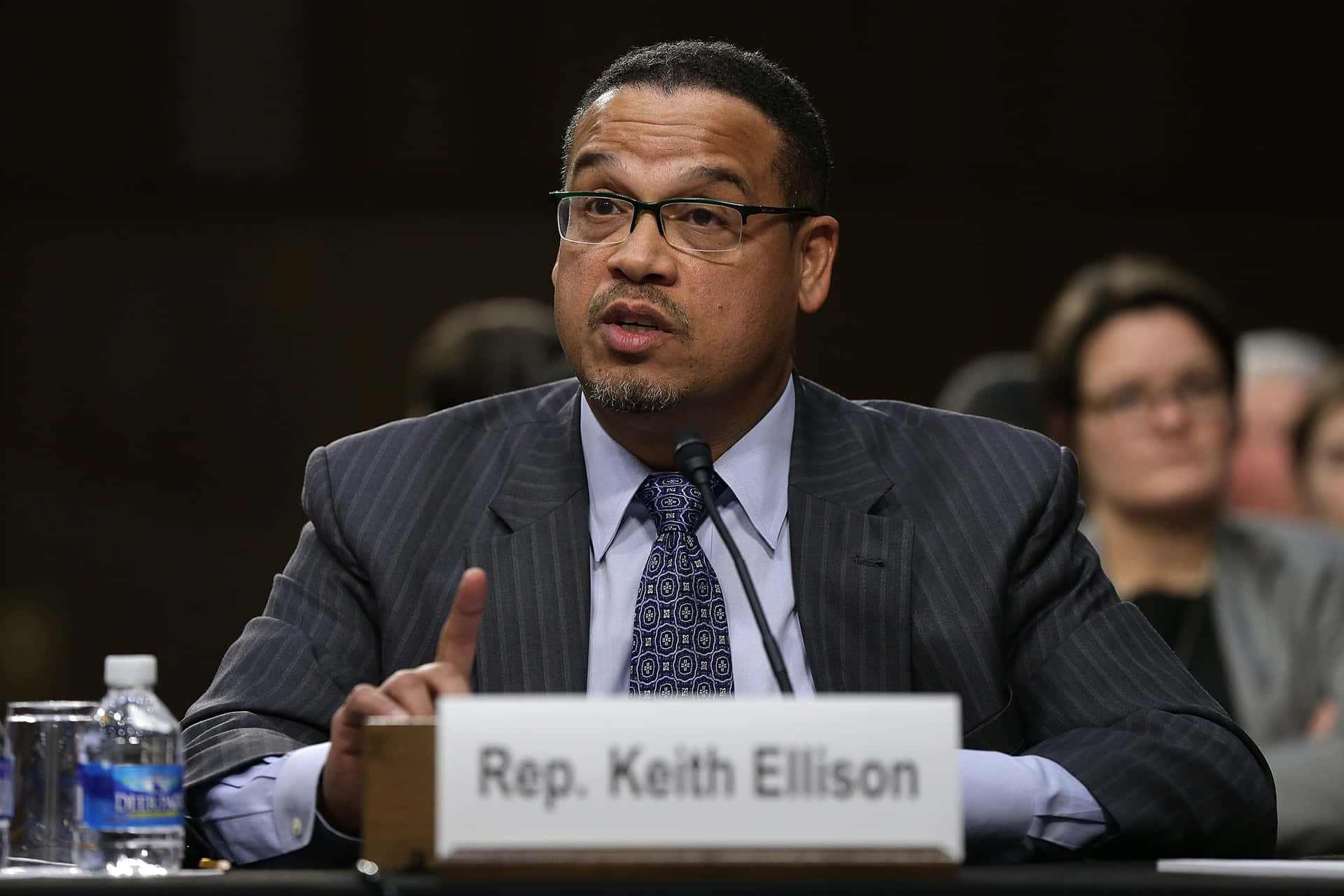 眾議員 Keith Ellison 穿著西裝打領帶在政府聽證會上發言。